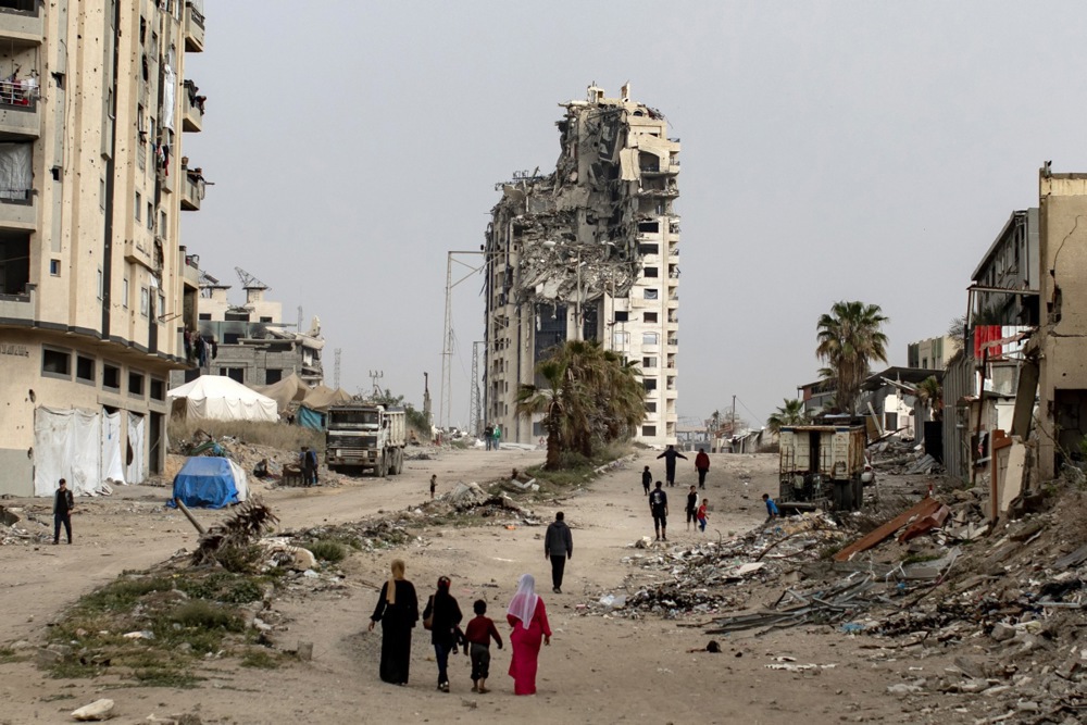 epa12014210 Internally displaced Palestinians walk past destroyed buildings in the west of Gaza City, the Gaza Strip, 06 April 2025, after the Israeli army issued evacuation orders for areas in the northern and eastern Gaza Strip. Israeli forces resumed airstrikes on Gaza on 18 March, ending a ceasefire that had been in place since 19 January. EPA-EFE/HAITHAM IMAD