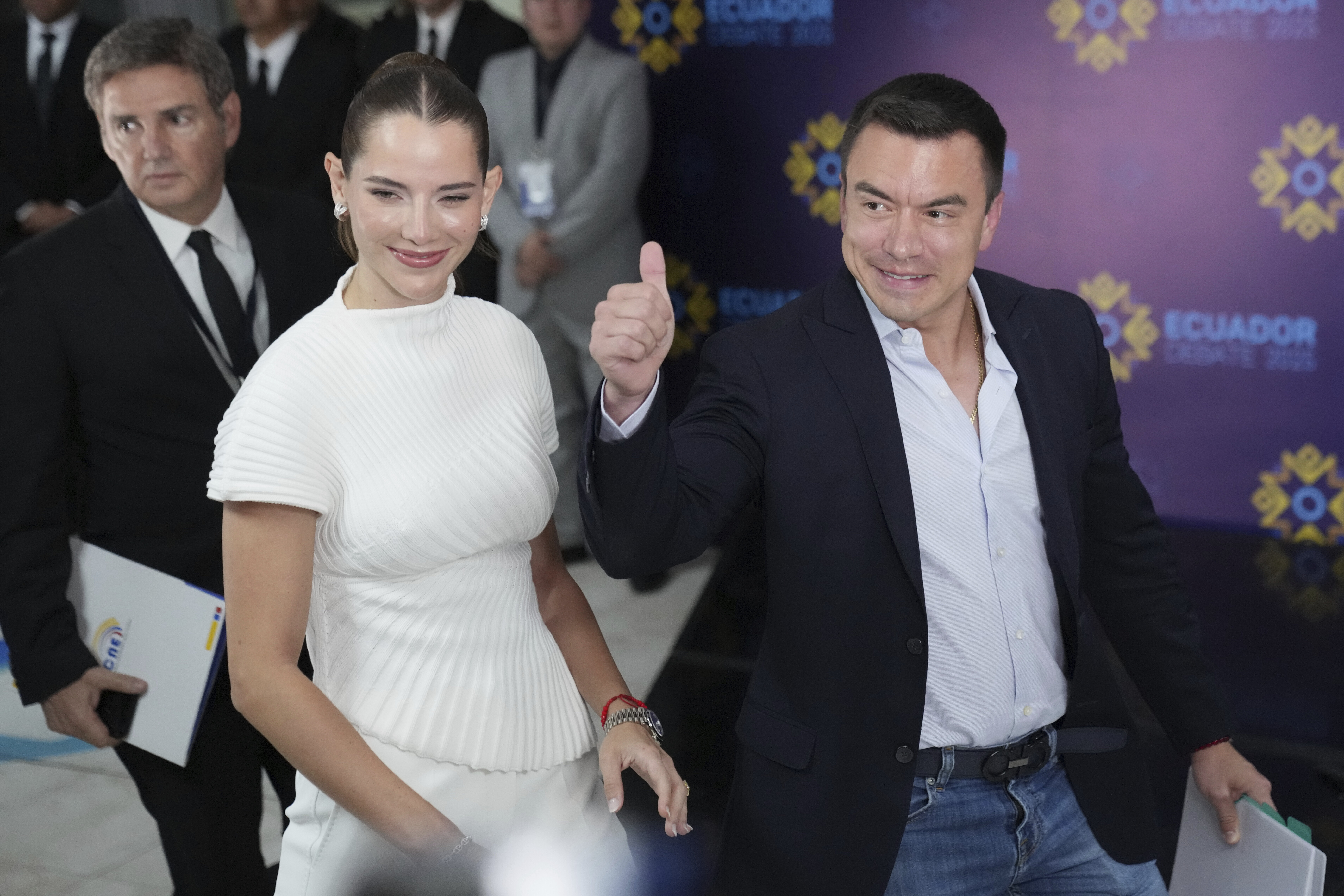 Daniel Noboa flashes a thumbs-up while walking with his wife Lavinia at a campaign event.