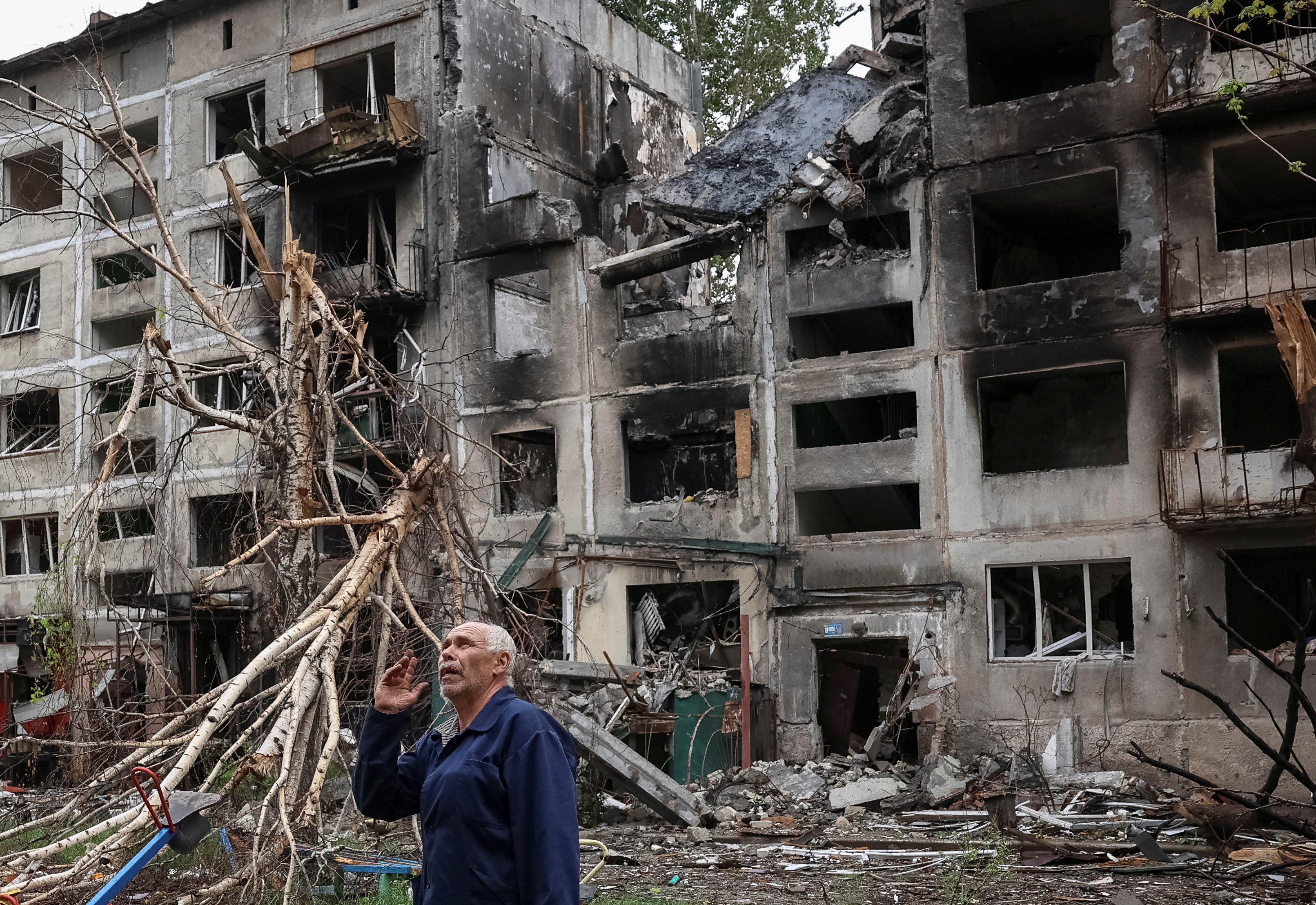 A resident gestures as he stands near buildings damaged by Russian military strikes, amid Russia's attack on Ukraine, in the frontline town of Myrnohrad, Donetsk region, Ukraine May 29, 2025. REUTERS/Anatolii Stepanov TPX IMAGES OF THE DAY