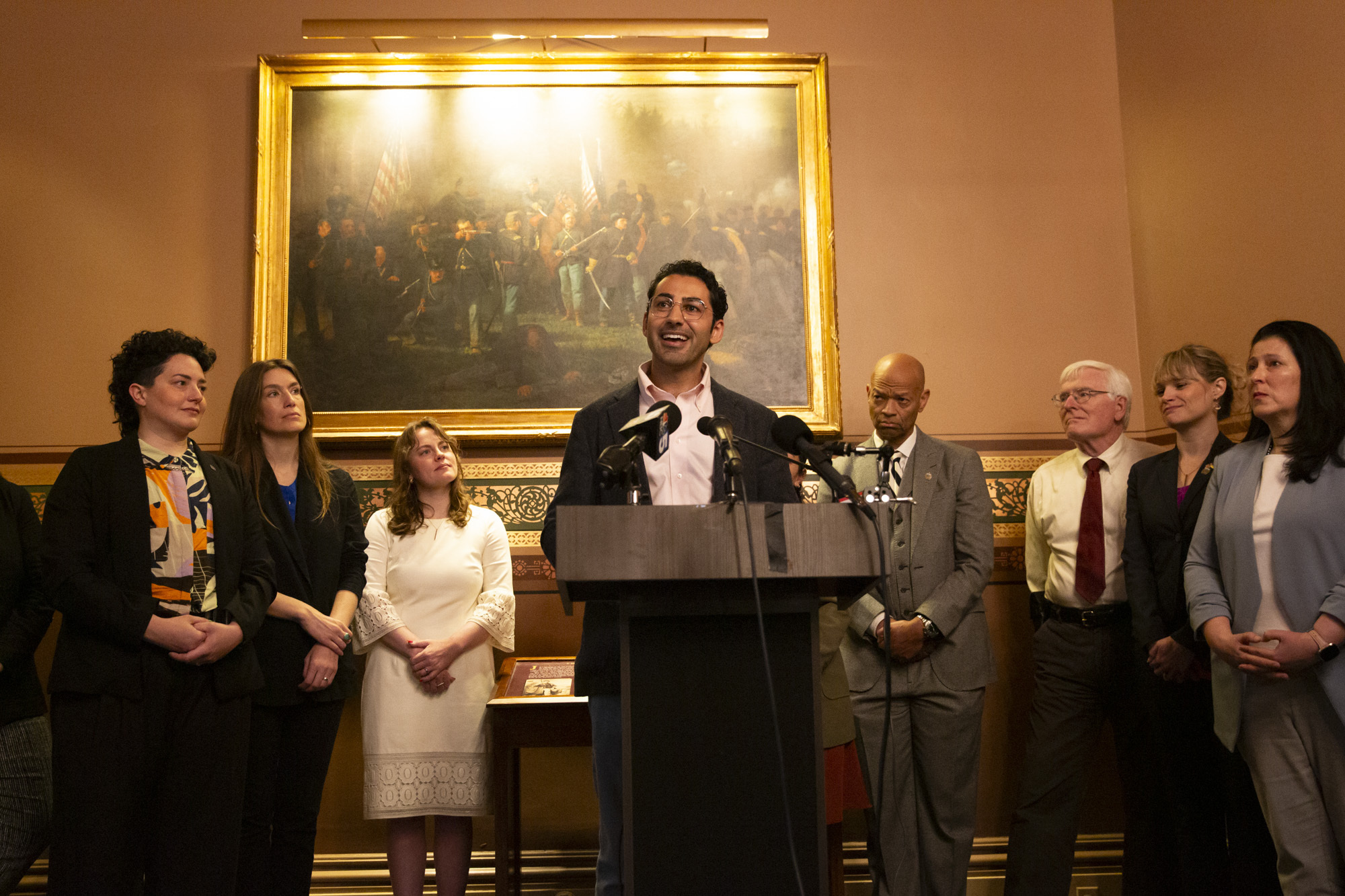 Mohsen Mahdawi speaks at a podium in the Vermont State House.