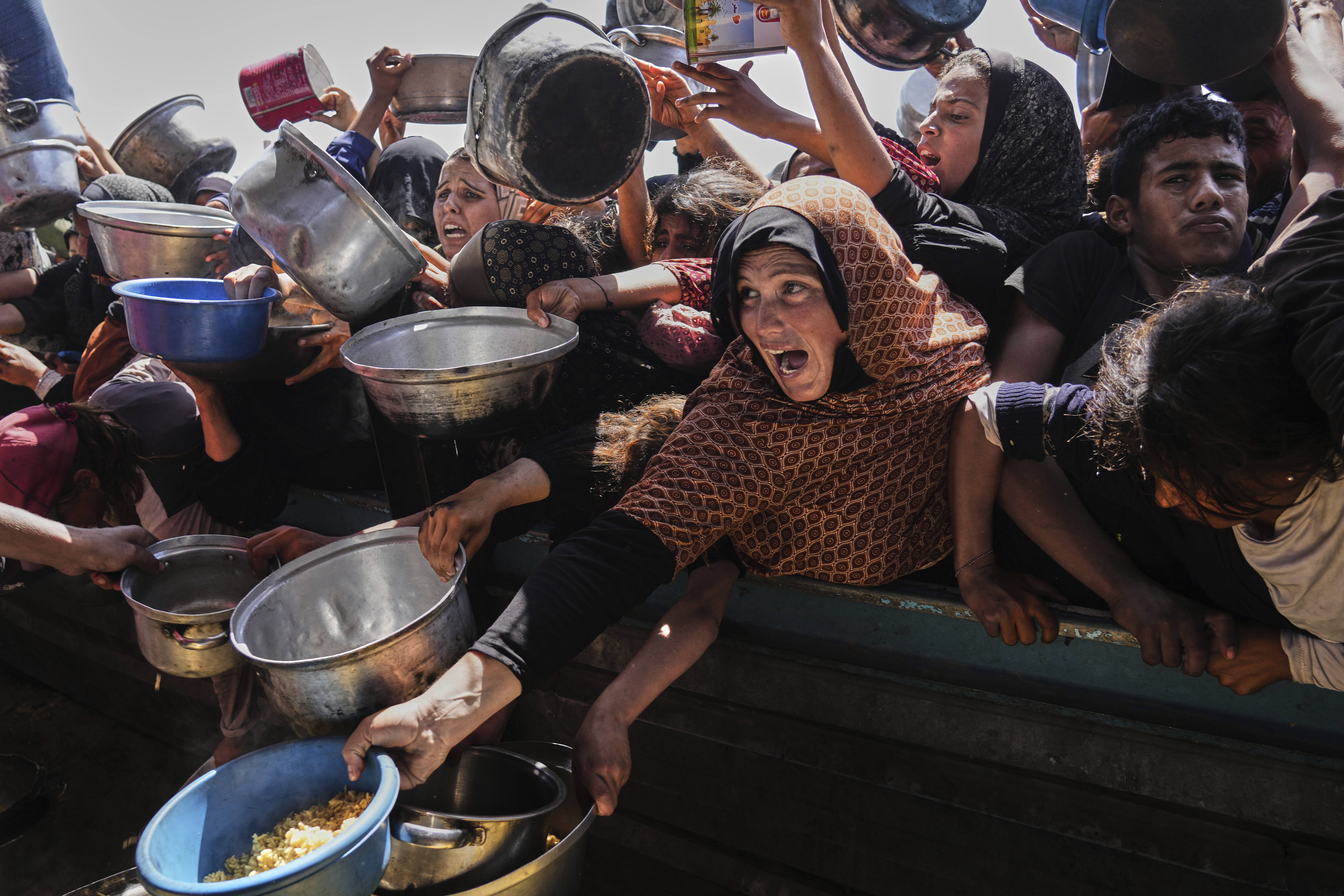 Palestinians struggle to obtain food at a community kitchen in Khan Younis, in the southern Gaza Strip