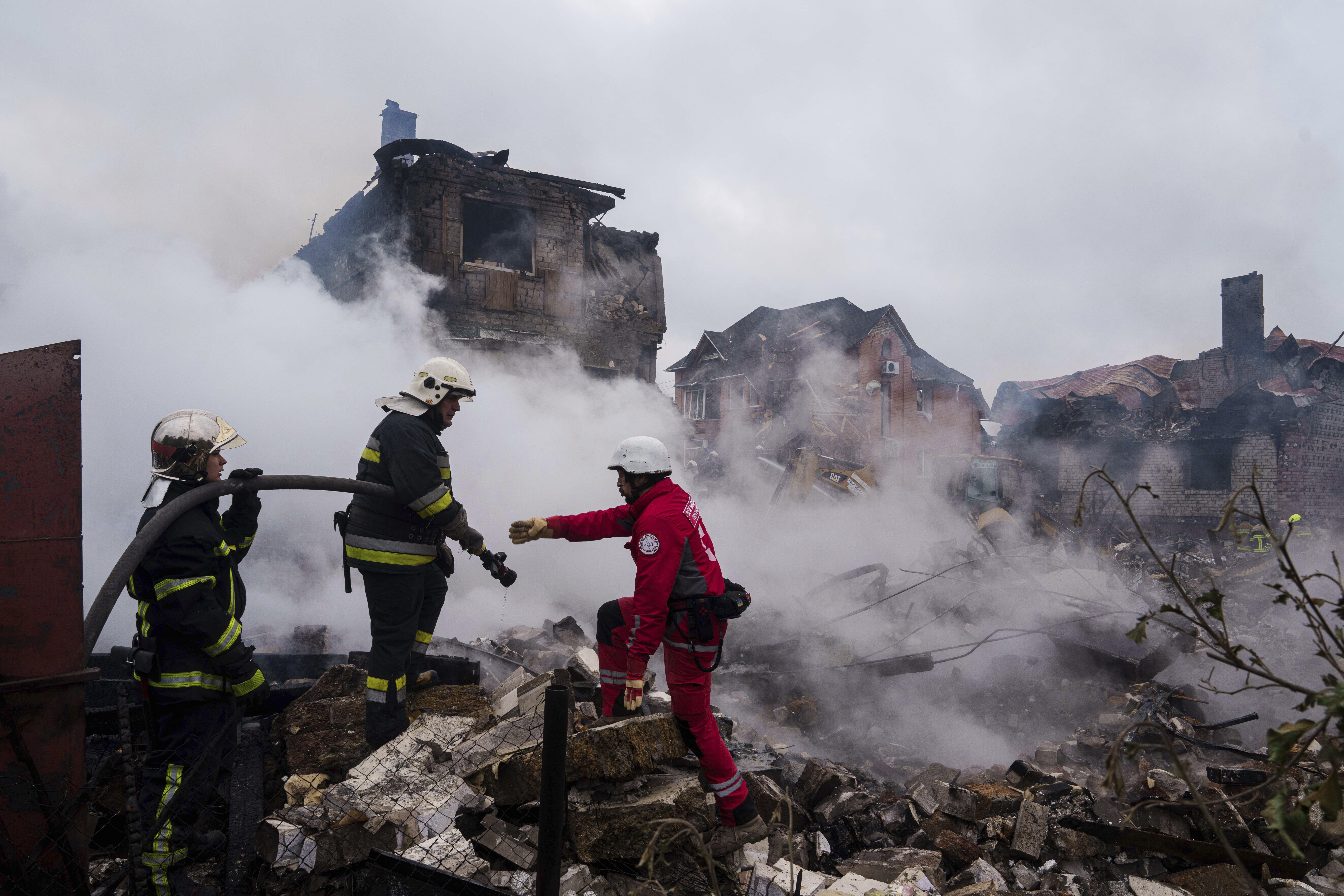 Rescue workers extinguish a fire of a house destroyed by a Russian strike in Markhalivka village, Kyiv region, Ukraine, Sunday, May 25, 2025