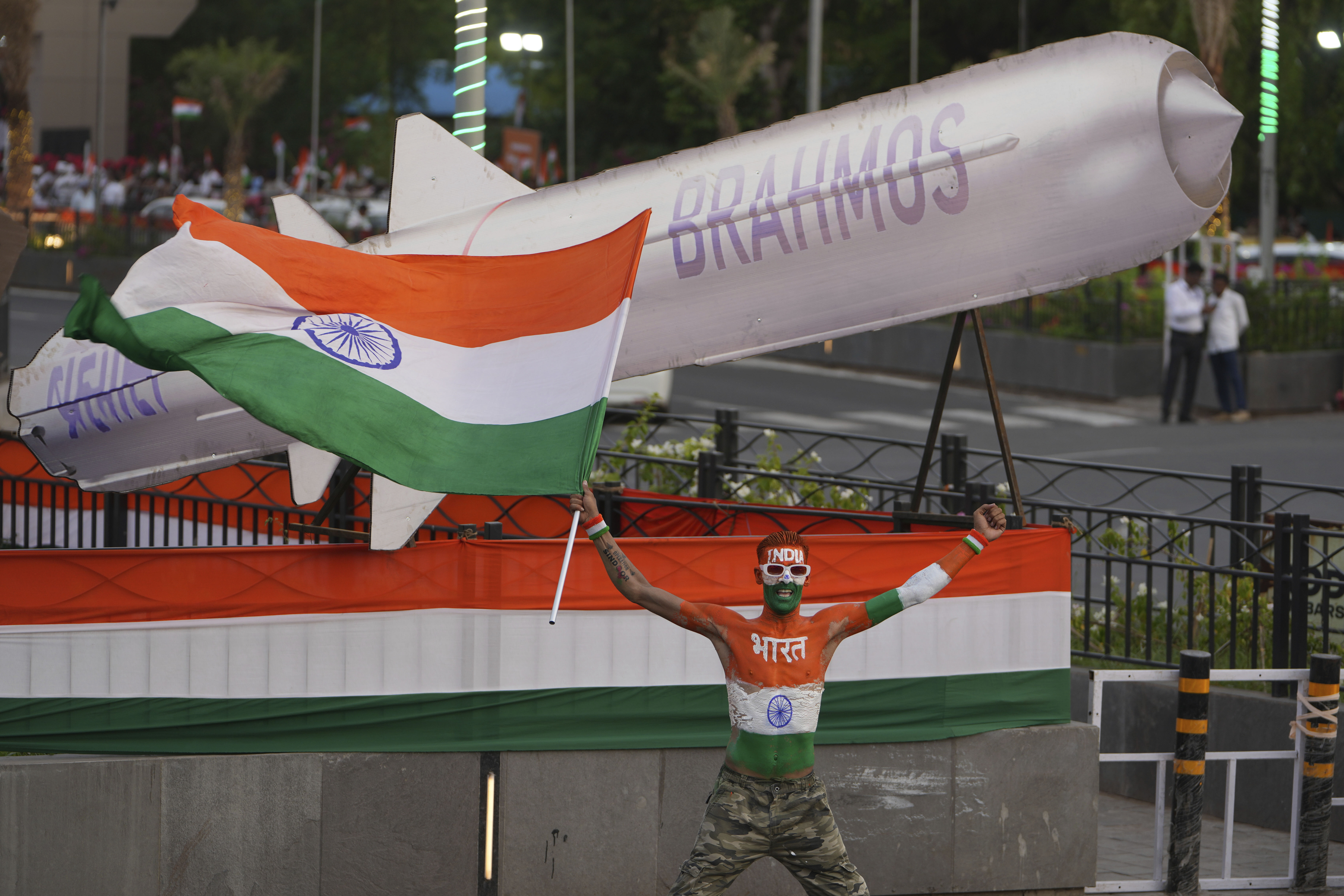 A man waves a national flag in front of a cut out of Brahmos Missile during Indian Prime Minister Narendra Modi's road show in Ahmedabad, India, Monday, May 26, 2025. (AP Photo/Ajit Solanki)