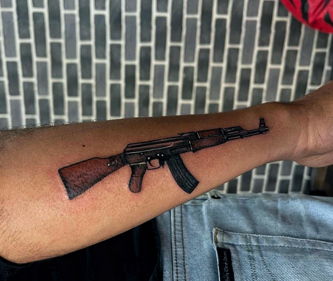 Photo 1: A Kashmiri youth shows a tattoo of an AK-47 on his forearm.