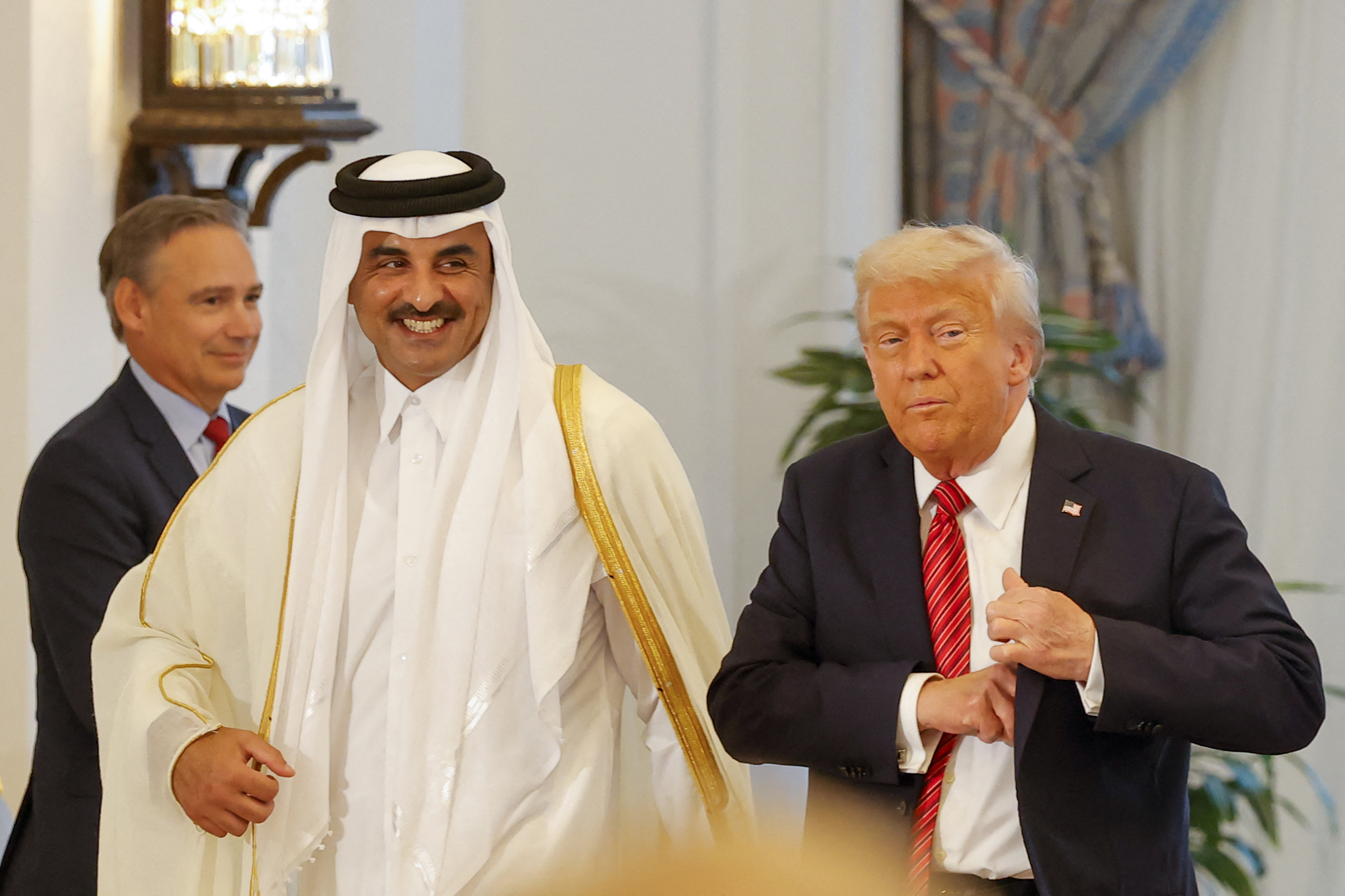 Qatar's Emir Sheikh Tamim bin Hamad al-Thani (L) and US President Donald Trump leave after a signing ceremony at the Royal Palace in Doha on May 14, 2025. (Photo by Karim JAAFAR / AFP)