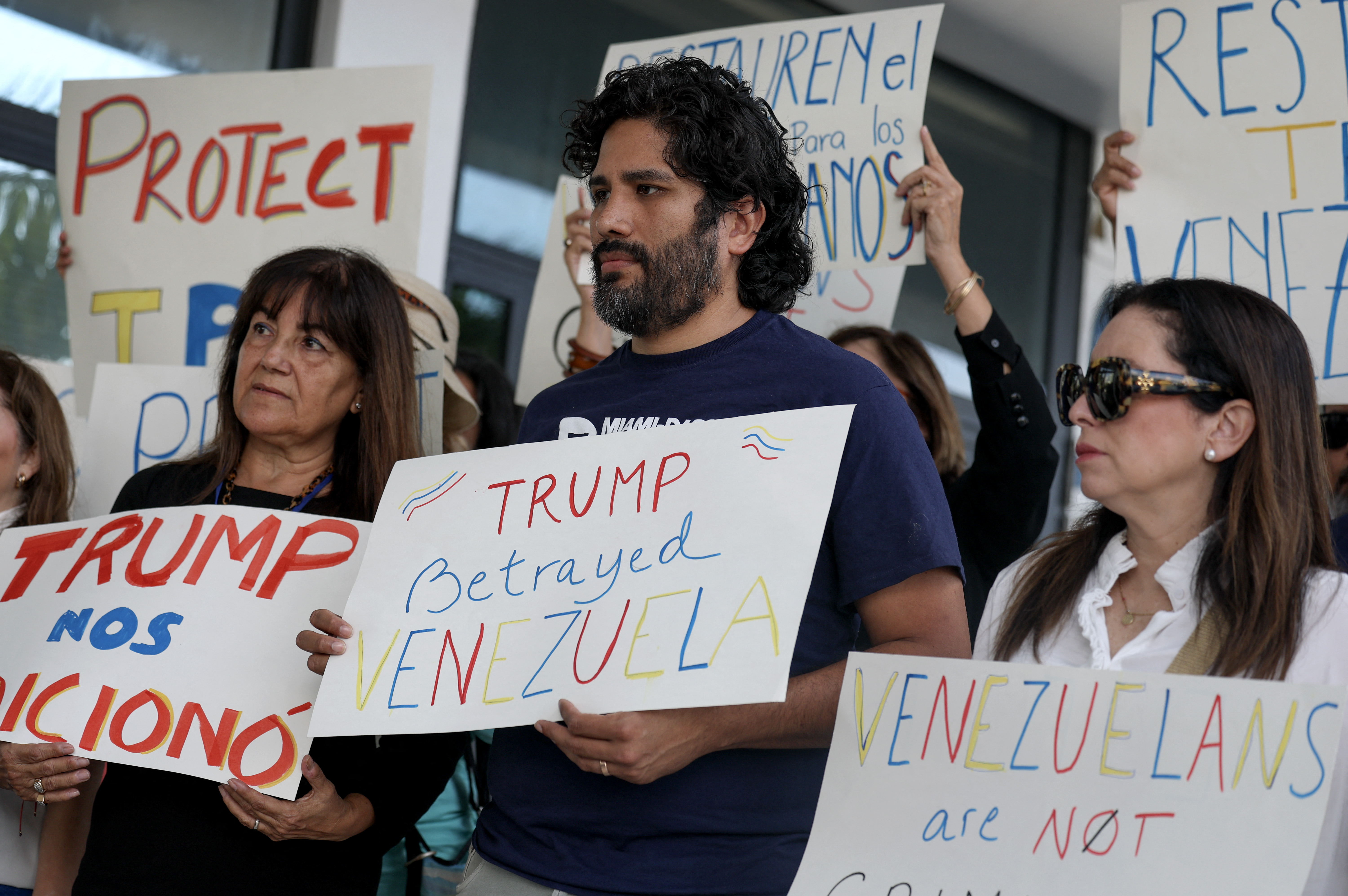 People stand together, holding up placards.