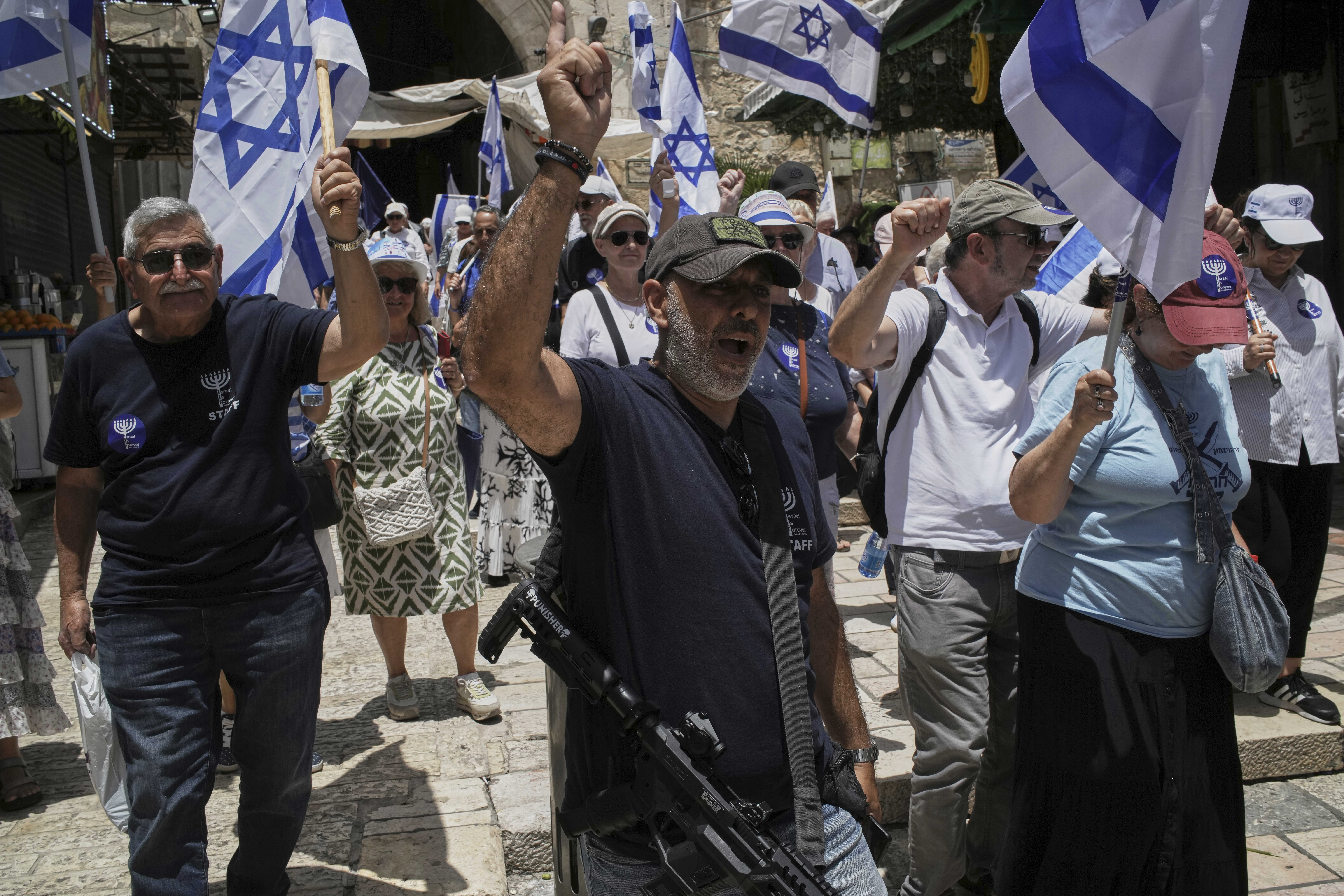 Israelis wave national flags during a march marking Jerusalem Day, an Israeli holiday celebrating the capture of east Jerusalem in the 1967 Mideast war, in Jerusalem's Old City, Monday, May 26, 2025. (AP Photo/Leo Correa)