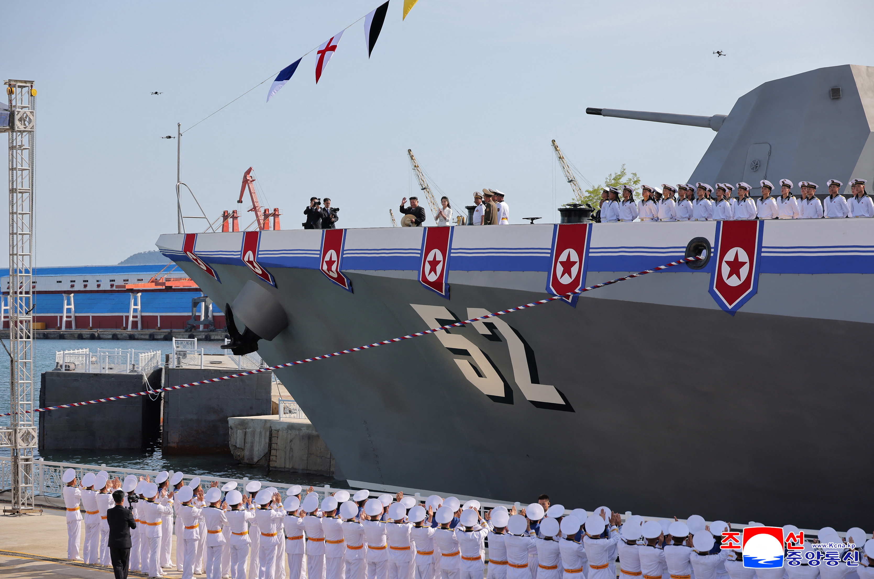 North Korean leader Kim Jong Un waves from on board a warship that had been damaged upon its first attempt to launch, as he and his daughter Kim Ju Ae attend the warship's launching ceremony, in Rajin, North Korea, June 12, 2025 in this photo released by North Korea's official Korean Central News Agency. KCNA via REUTERS ATTENTION EDITORS - THIS IMAGE WAS PROVIDED BY A THIRD PARTY. REUTERS IS UNABLE TO INDEPENDENTLY VERIFY THIS IMAGE. NO THIRD PARTY SALES. SOUTH KOREA OUT. NO COMMERCIAL OR EDITORIAL SALES IN SOUTH KOREA.