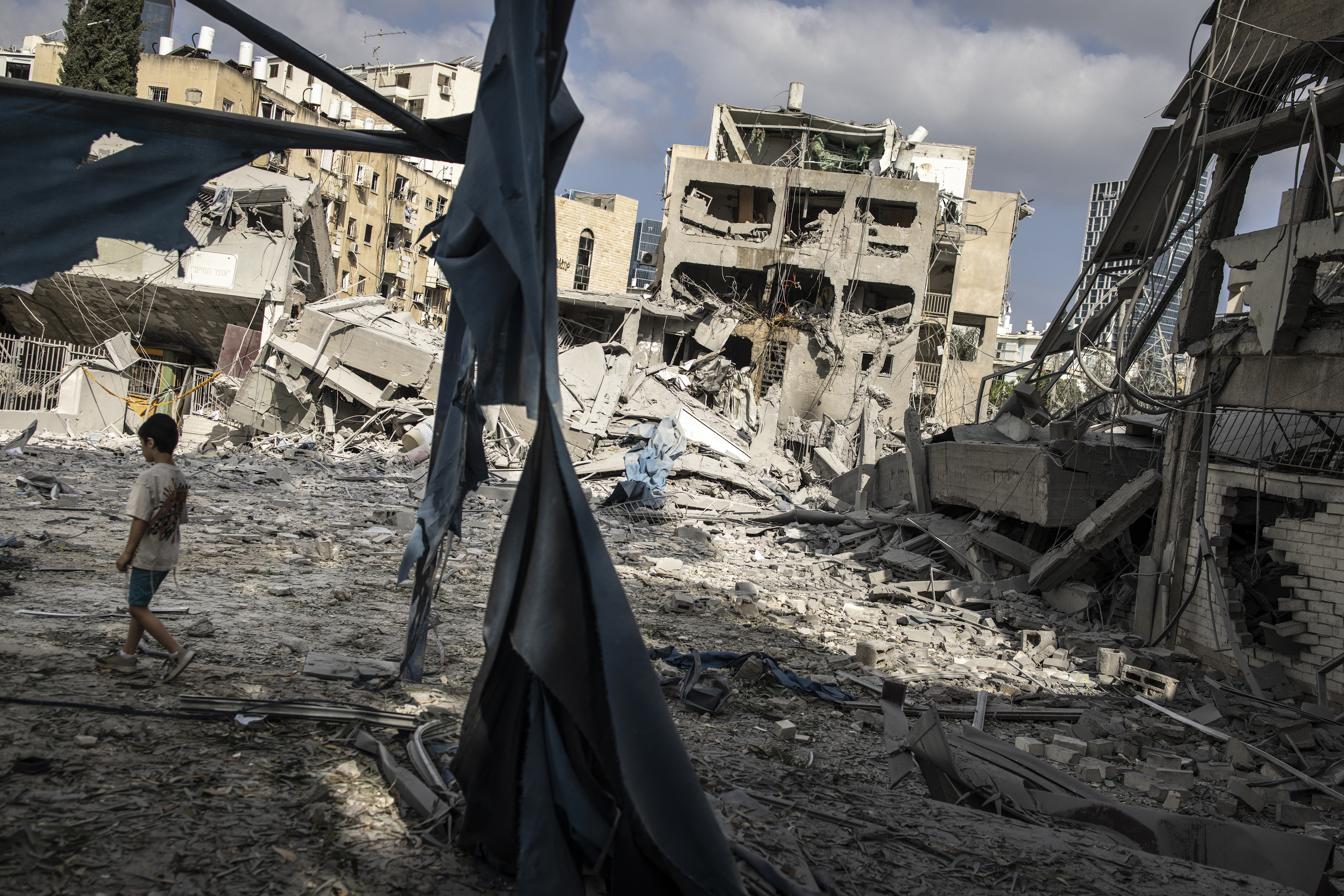 A young boy walks through the debris at the site of an Iranian missile strike in Bnei Brak, east of Tel Aviv