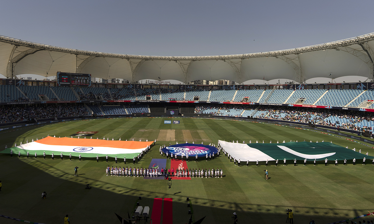 Indian, left, and Pakistan players stand for their national anthem before the start of the ICC Women's T20 World Cup 2024 match between Pakistan and India at Dubai International Stadium, United Arab Emirates, Sunday, Oct. 6, 2024. (AP Photo/Altaf Qadri)