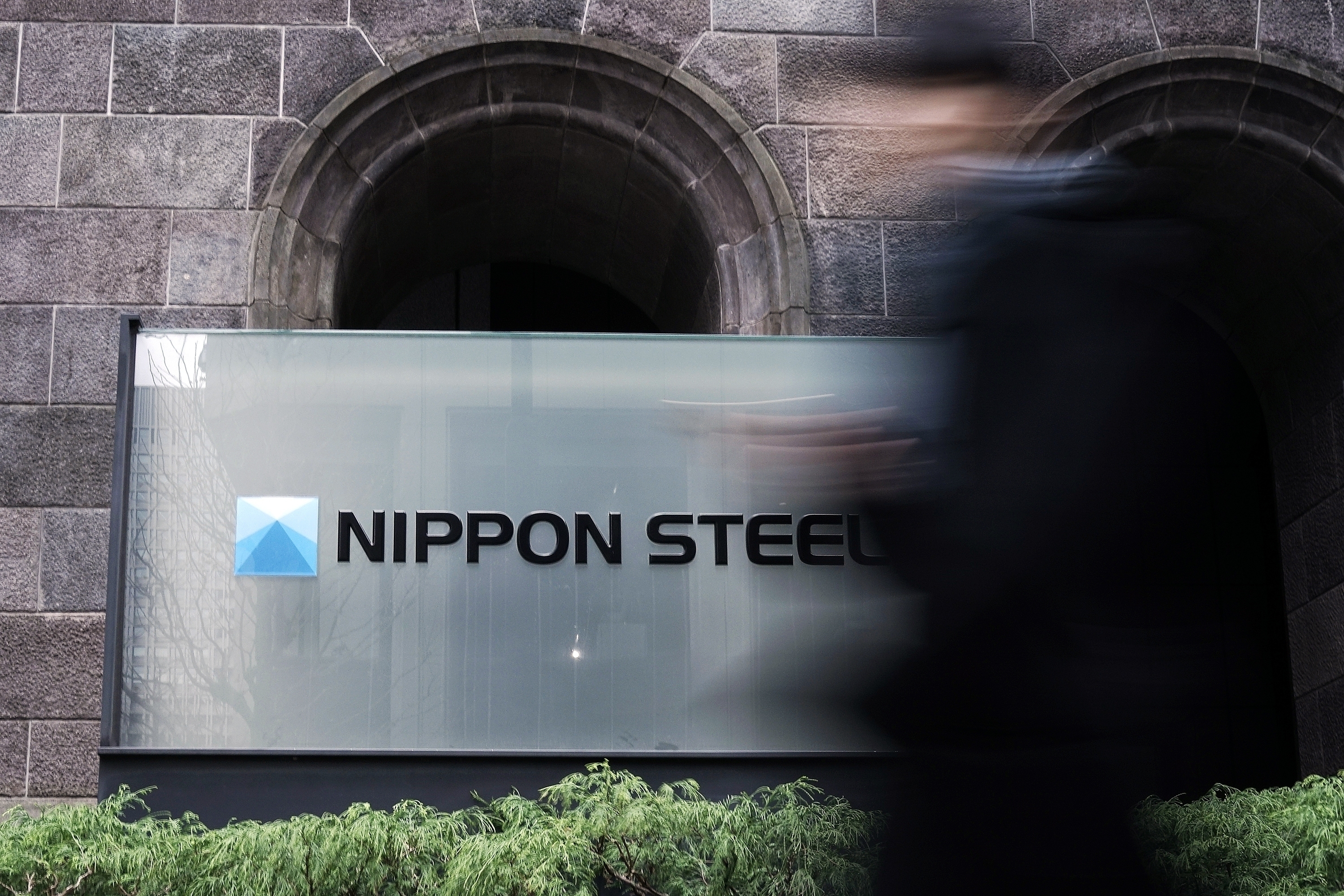 FILE - A person walks past a Nippon Steel Corporation sign at the company headquarters on Jan. 7, 2025, in Tokyo. (AP Photo/Eugene Hoshiko, File)