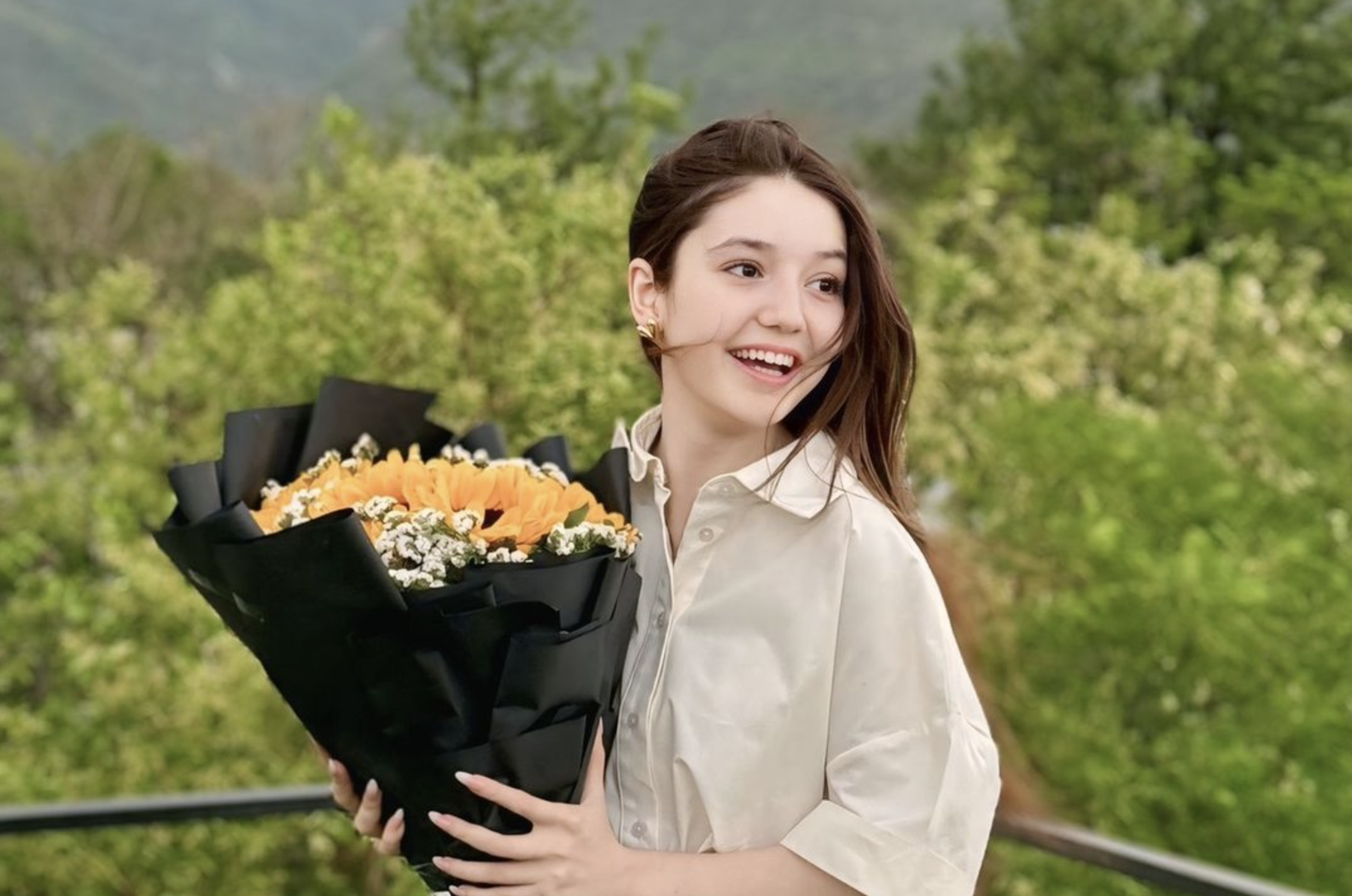 Sana Yousaf holding a bunch of flowers.
