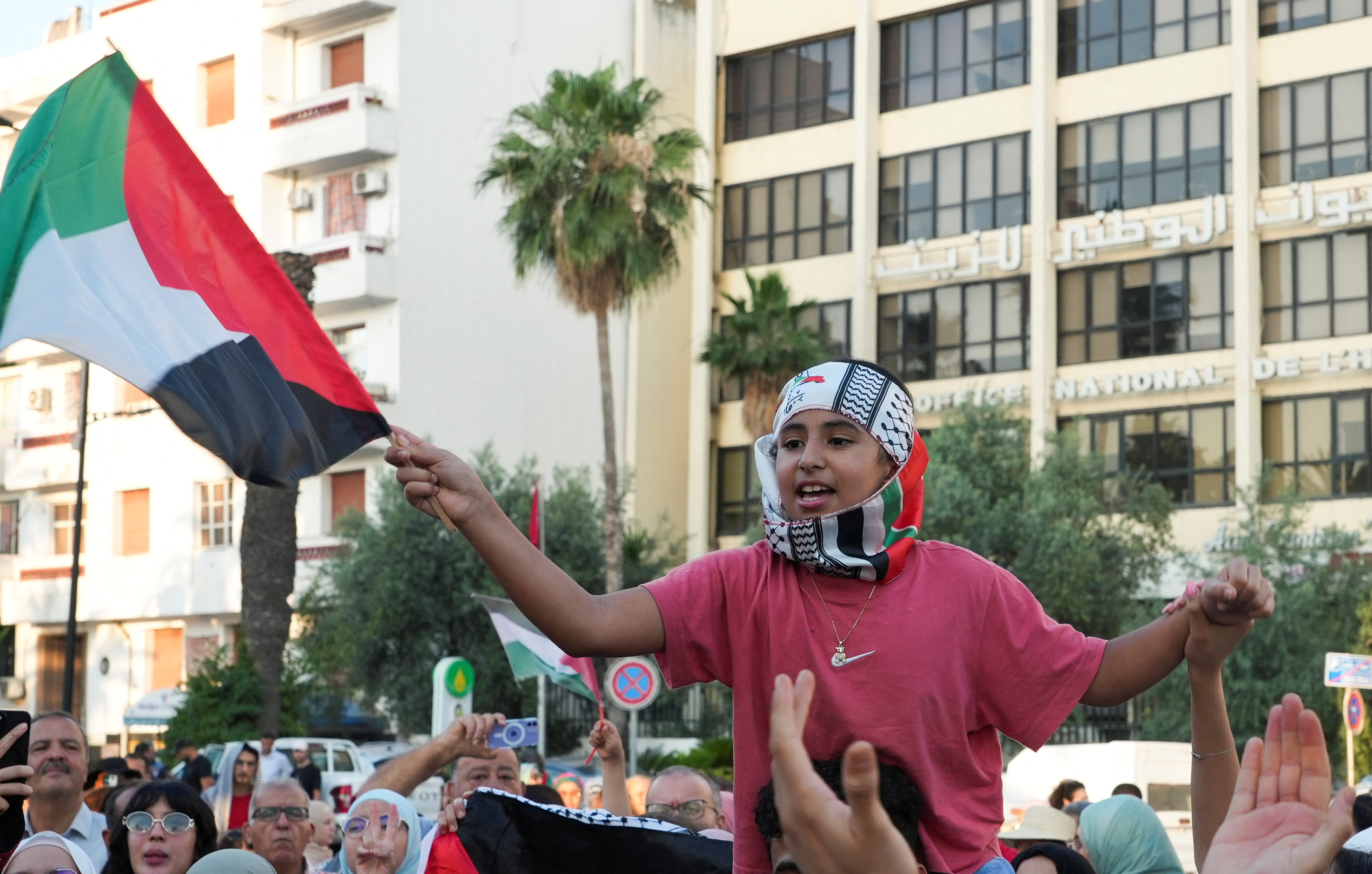 A child holds a Palestinian flag as participants of a Tunisian-led land convoy in Tunis
