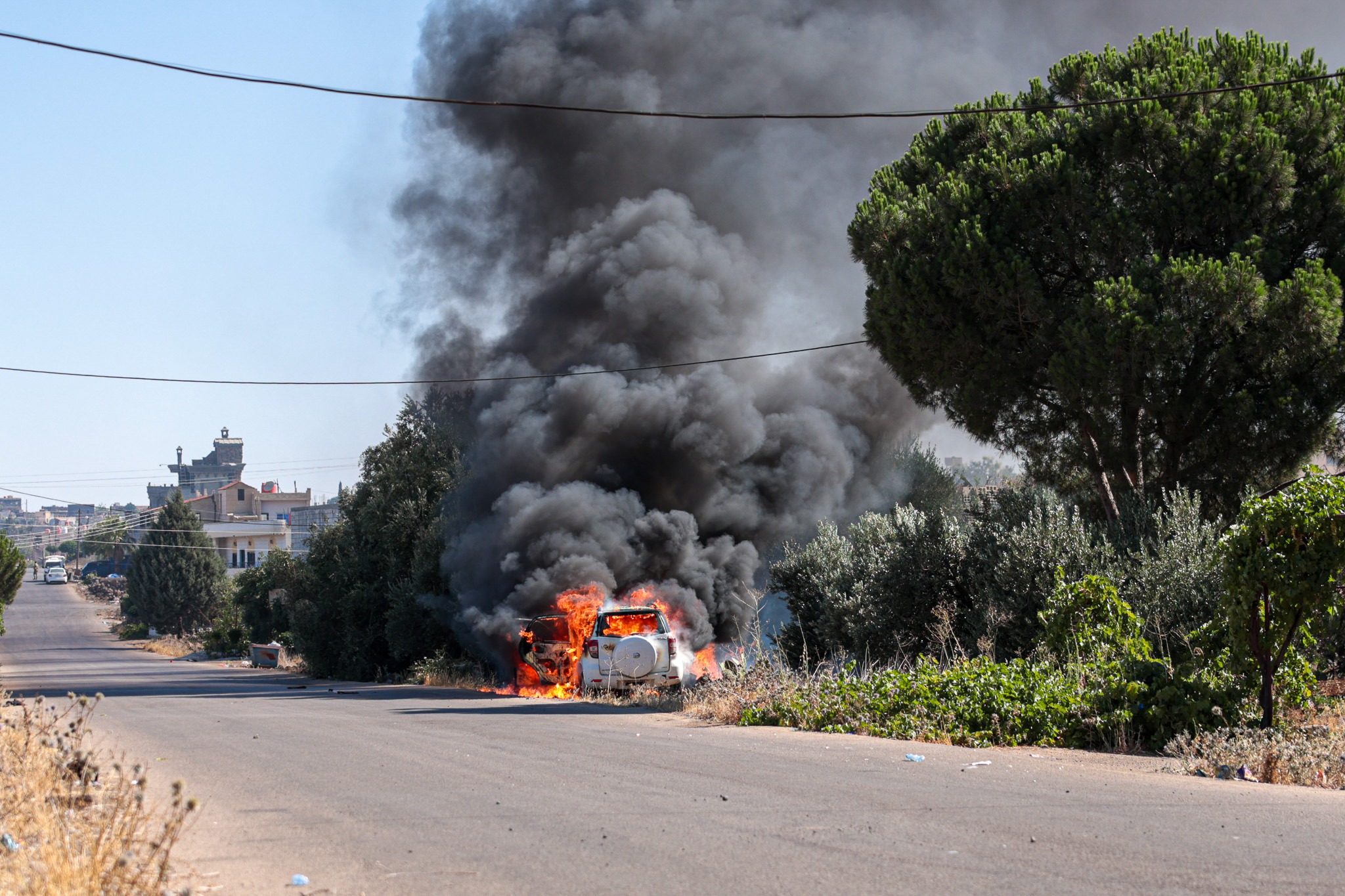 A vehicle is ablaze amid ongoing clashes in the southern city of Sweida, Syria