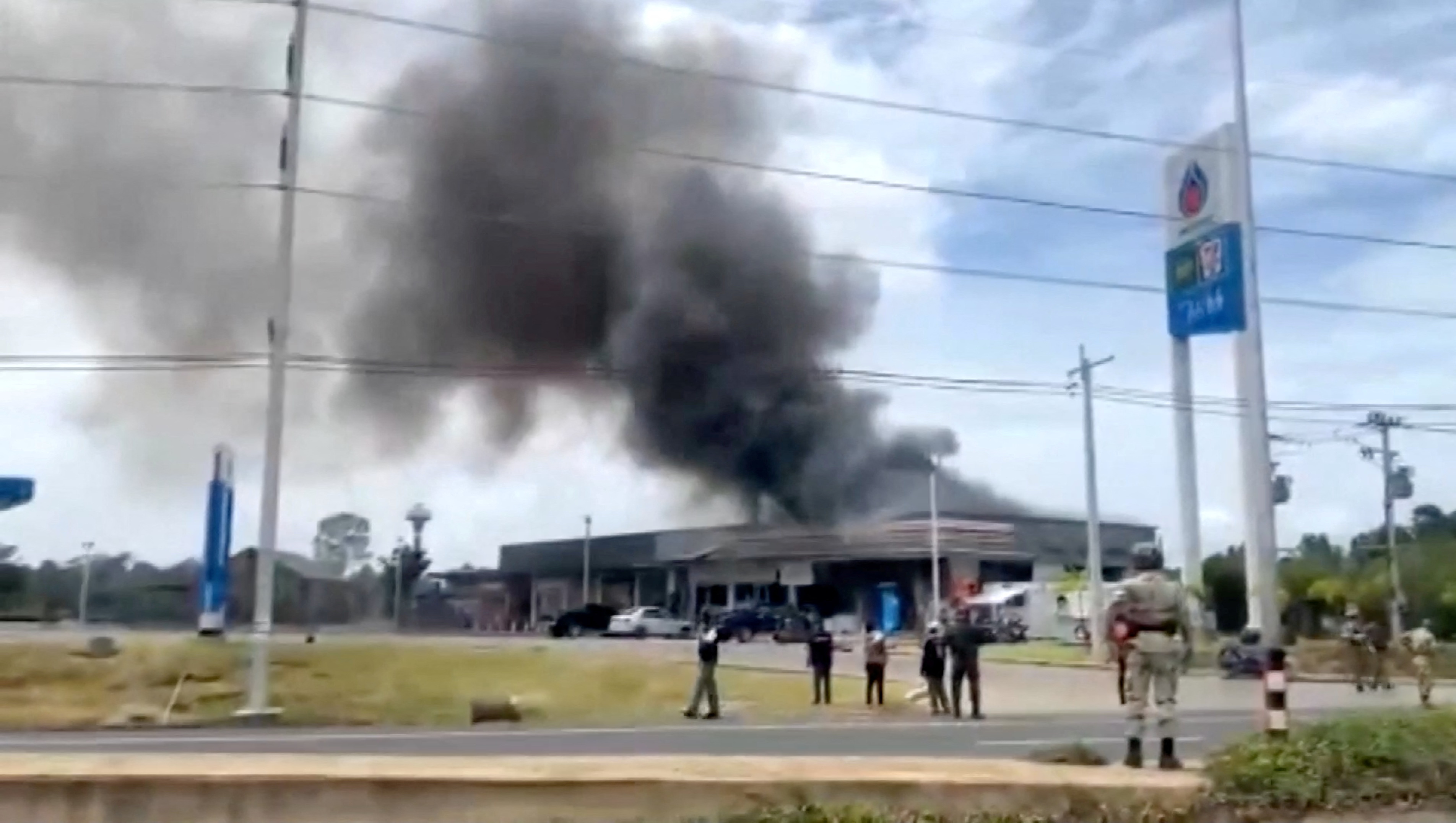 Smoke rises from a convenience store at a gas station.