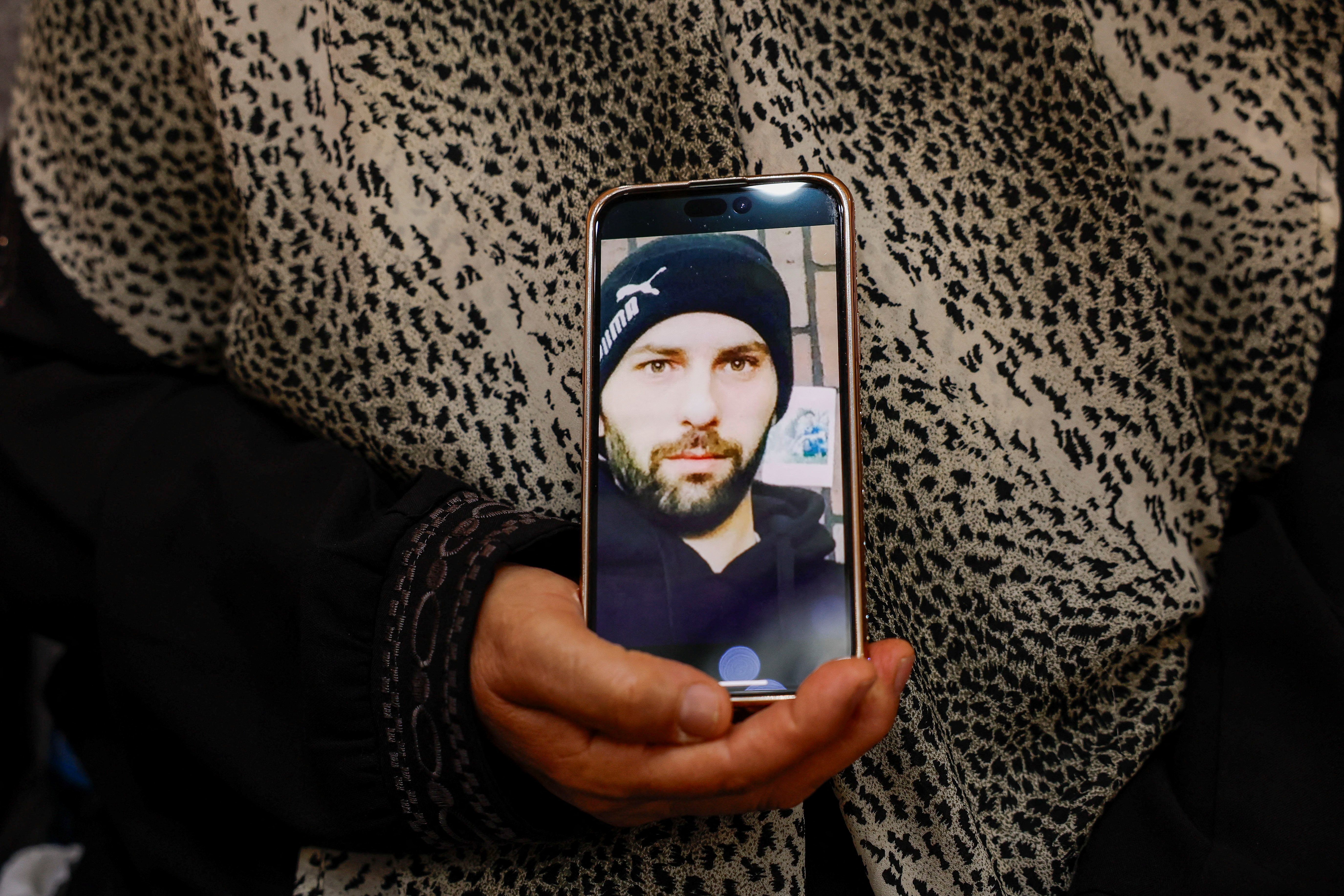 Haleema Ayyad holds her son's photo on a phone