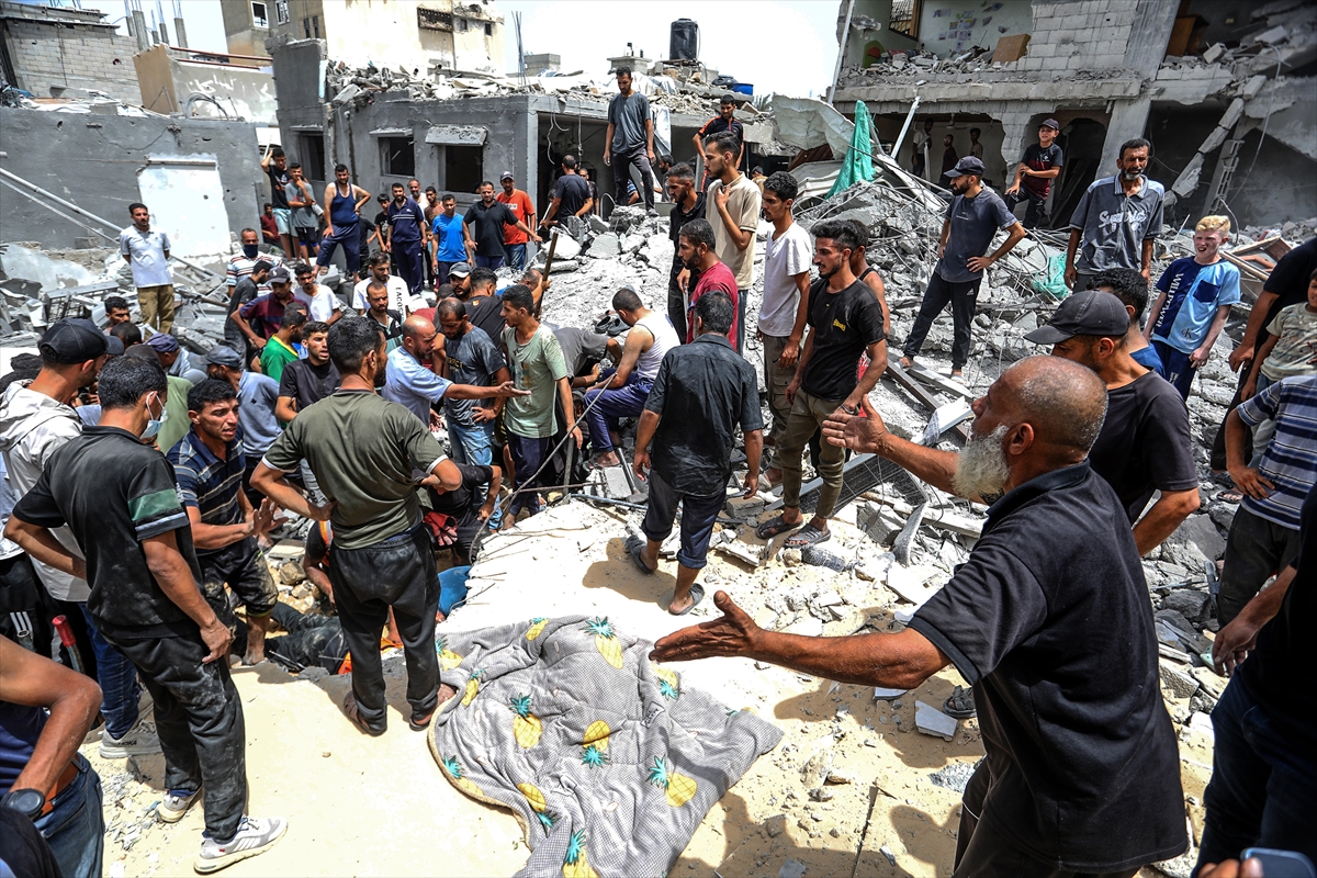 people search through a collapsed building as crowds gather