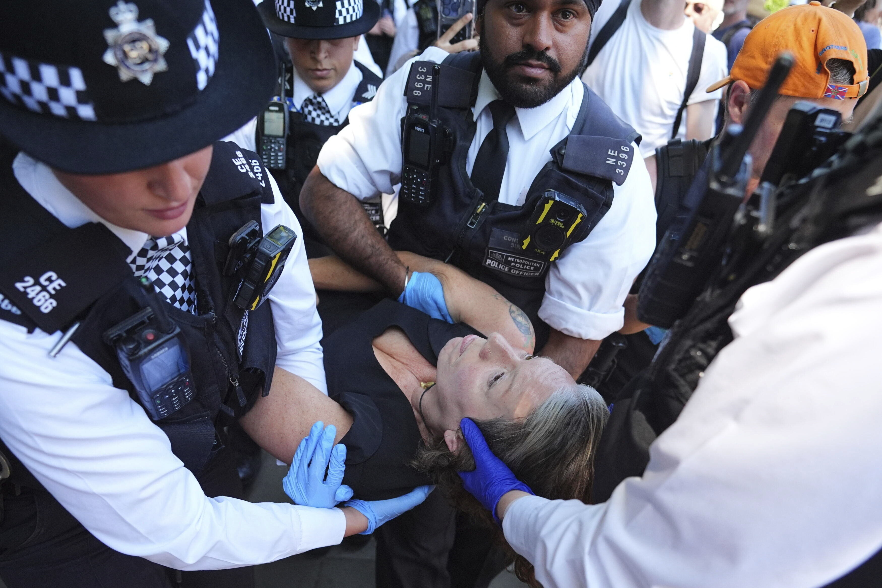 Police officers remove a person after they took part in a protest in Parliament Square, London, to call for de-proscription of Palestine Action