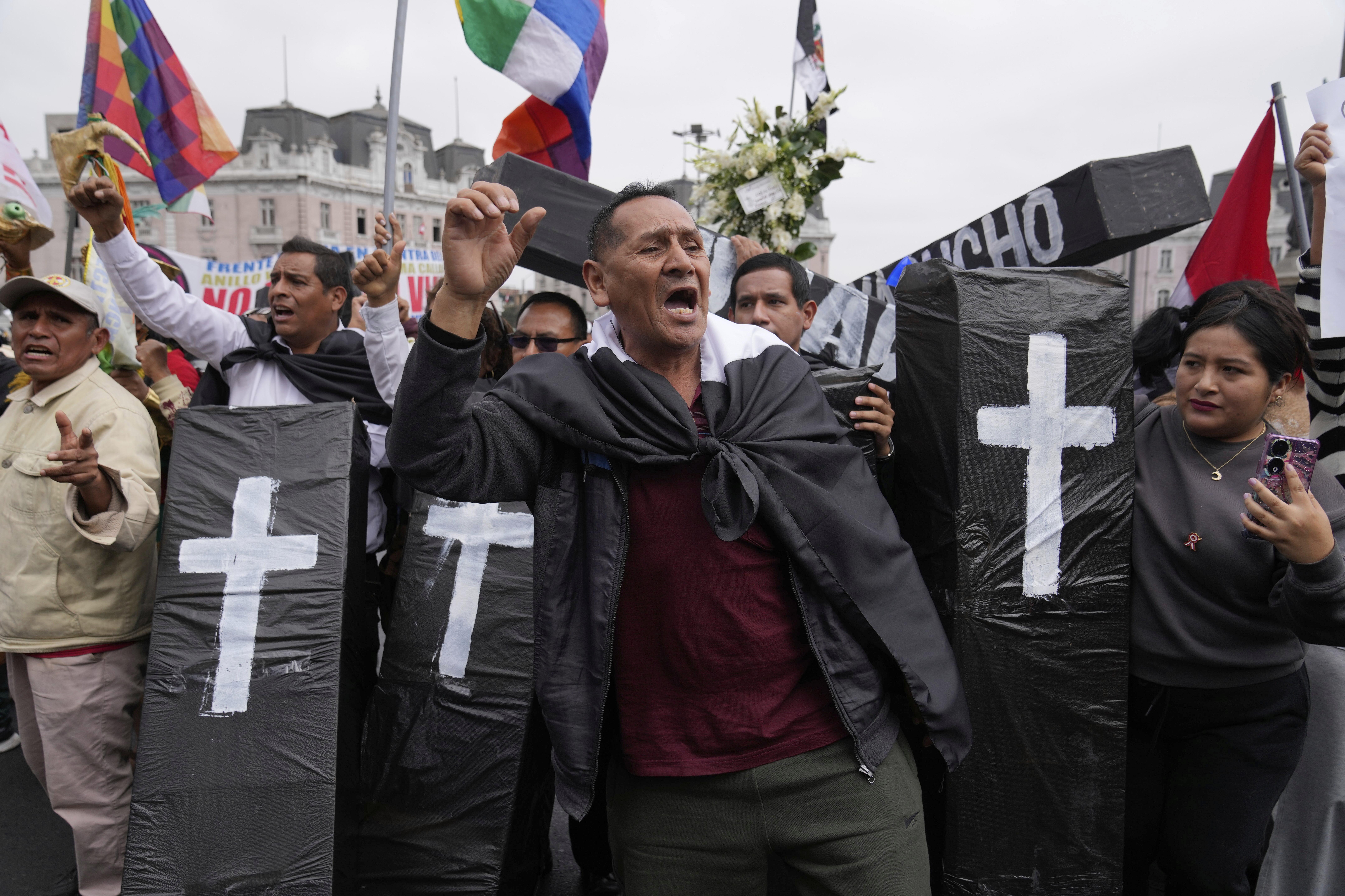 Protesters hold up model coffins to represent the dead.