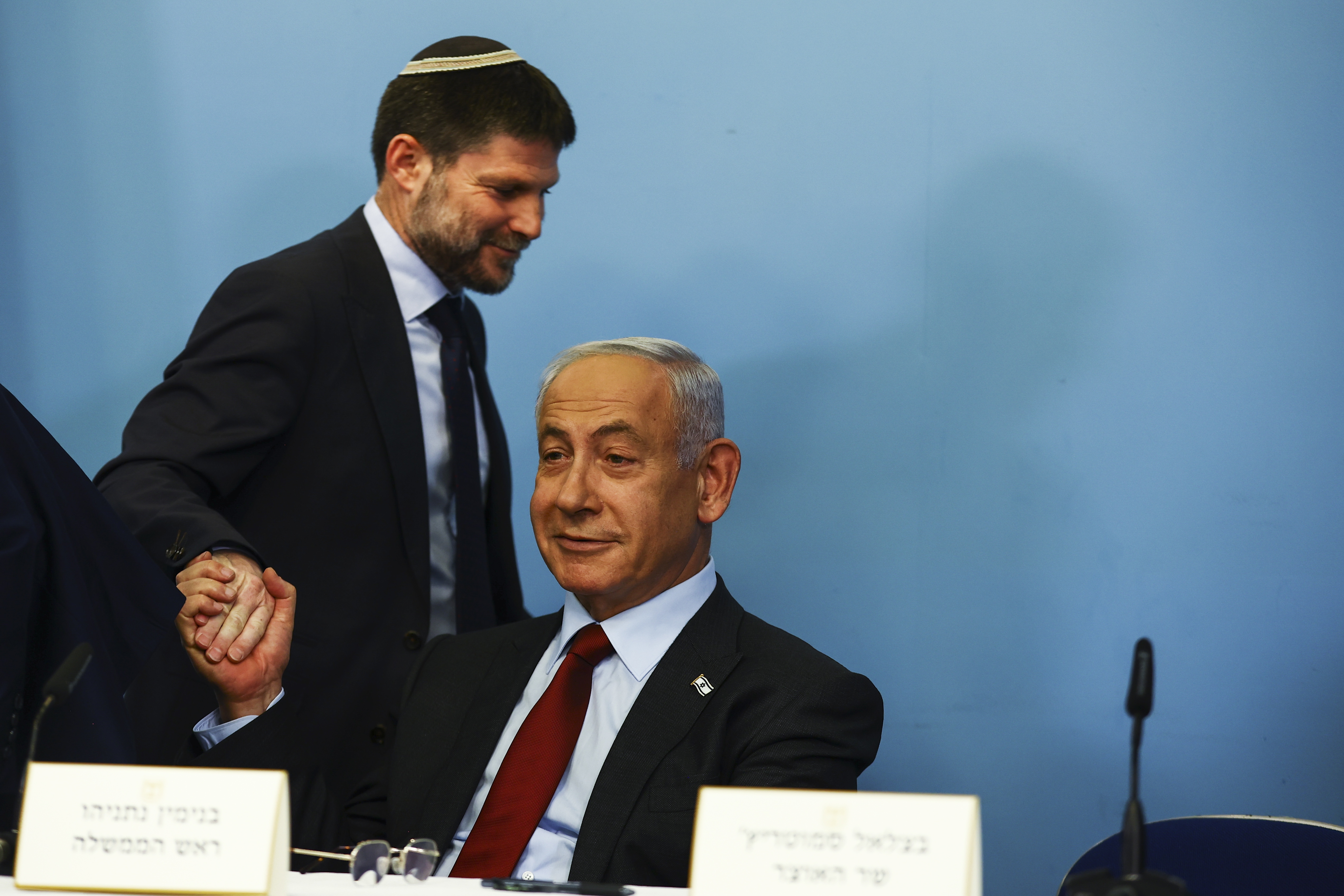 epa10429466 Israeli Finance Minister Bezalel Smotrich shakes the hand of Israeli Prime Minister Benjamin Netanyahu as they hold a news conference at the Prime Minister's office in Jerusalem, Israel, 25 January 2023. EPA/RONEN ZVULUN / POOL
