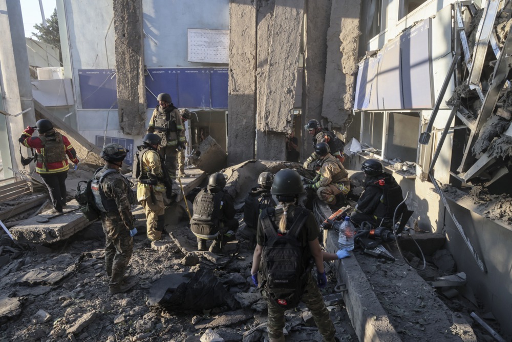 Ukrainian rescuers and policemen work at the site of the Russian strike on a bus station in Zaporizhzhia, Ukraine, on August 10, 2025