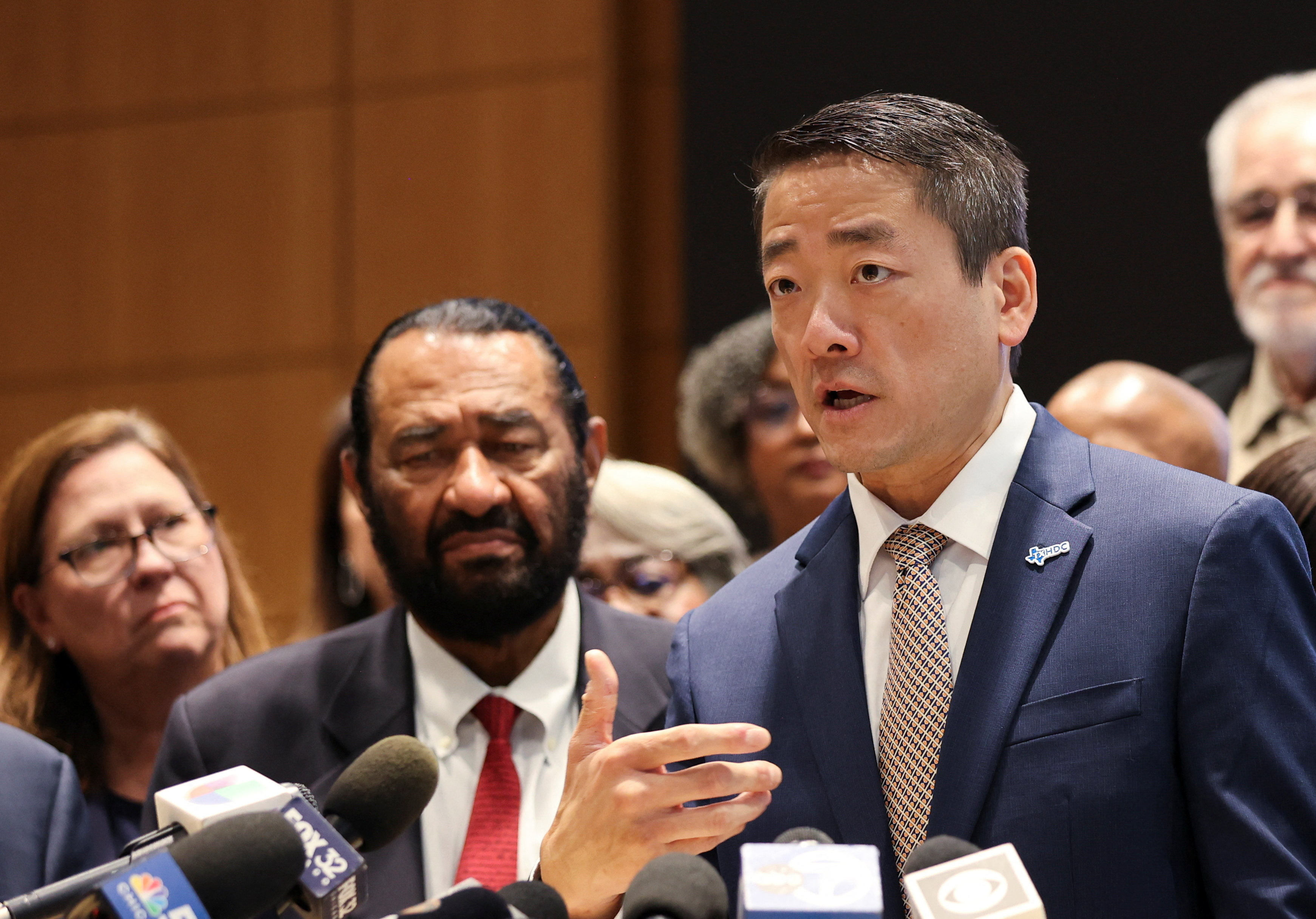 men in suits speak at a press conference