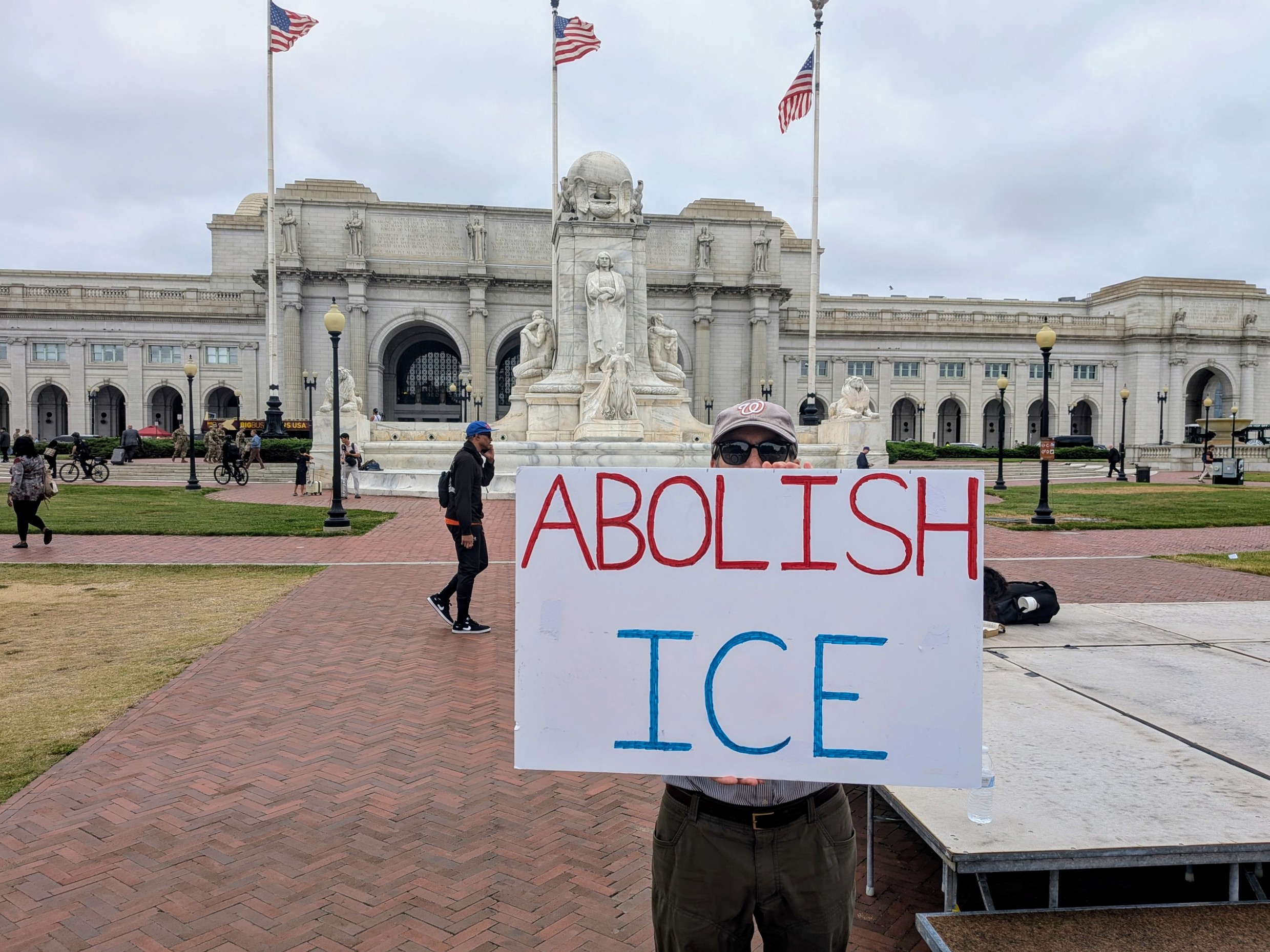 Man holding a sign thaat says, "abolish ICE"