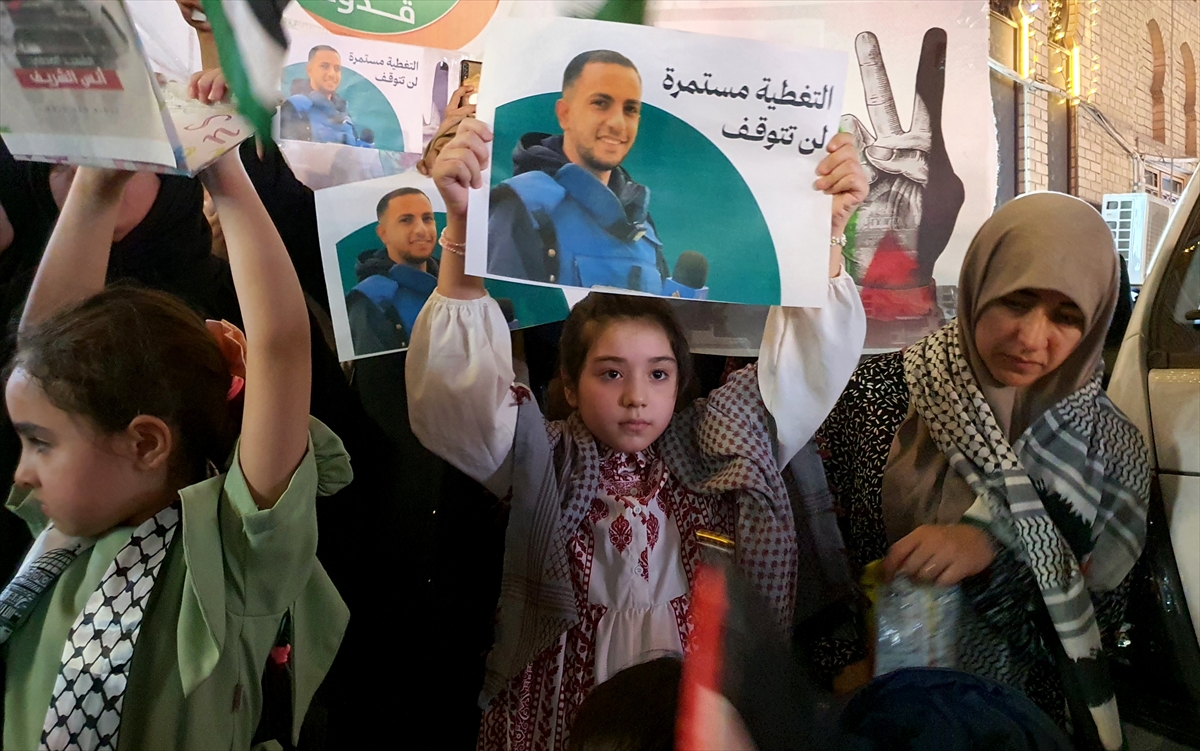 children hold photographs of journalists at a protest