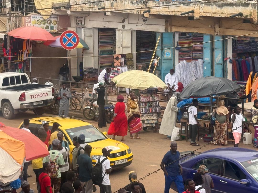 People walk down a busy street in Banjul, The Gambia.