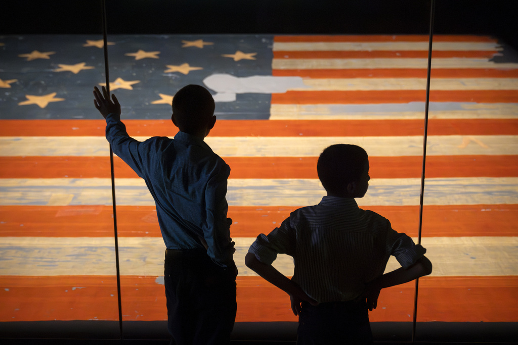 two children can be seen in front of the USA flag