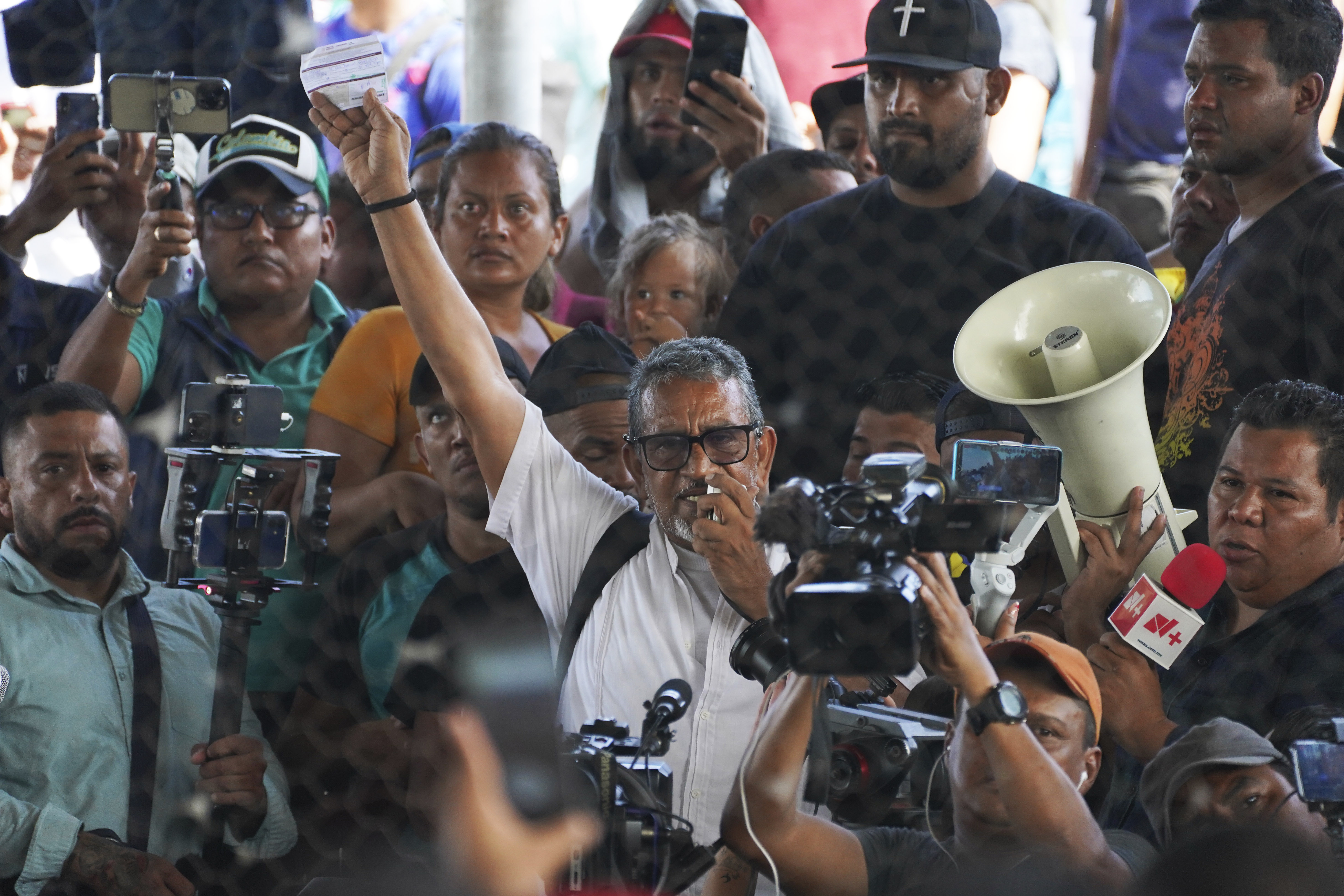Luis Garcia Villagrain raises a fist in front of media cameras.