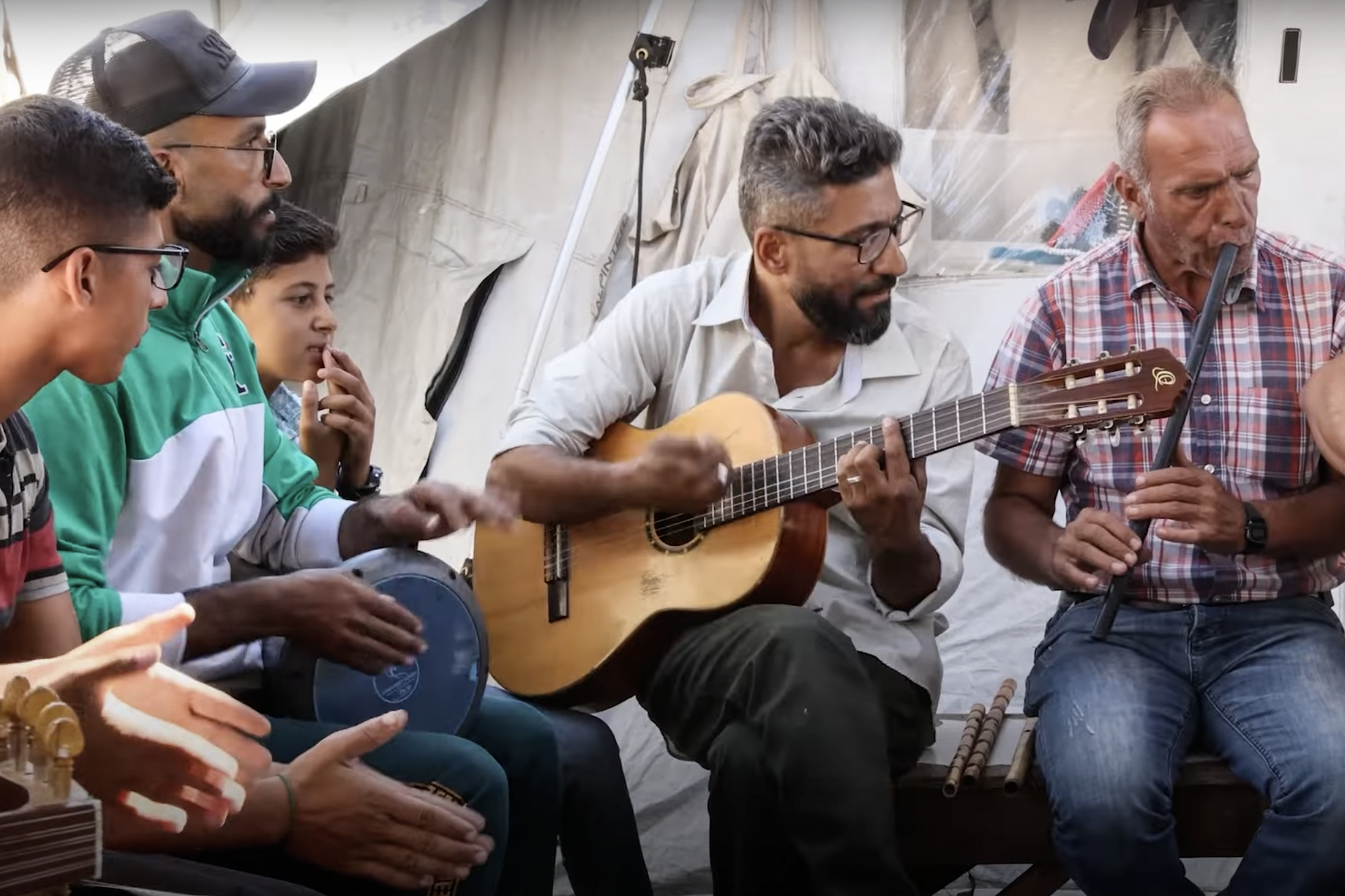 Music teacher Ahmad Abu Amsha performs for children and adults in Gaza.