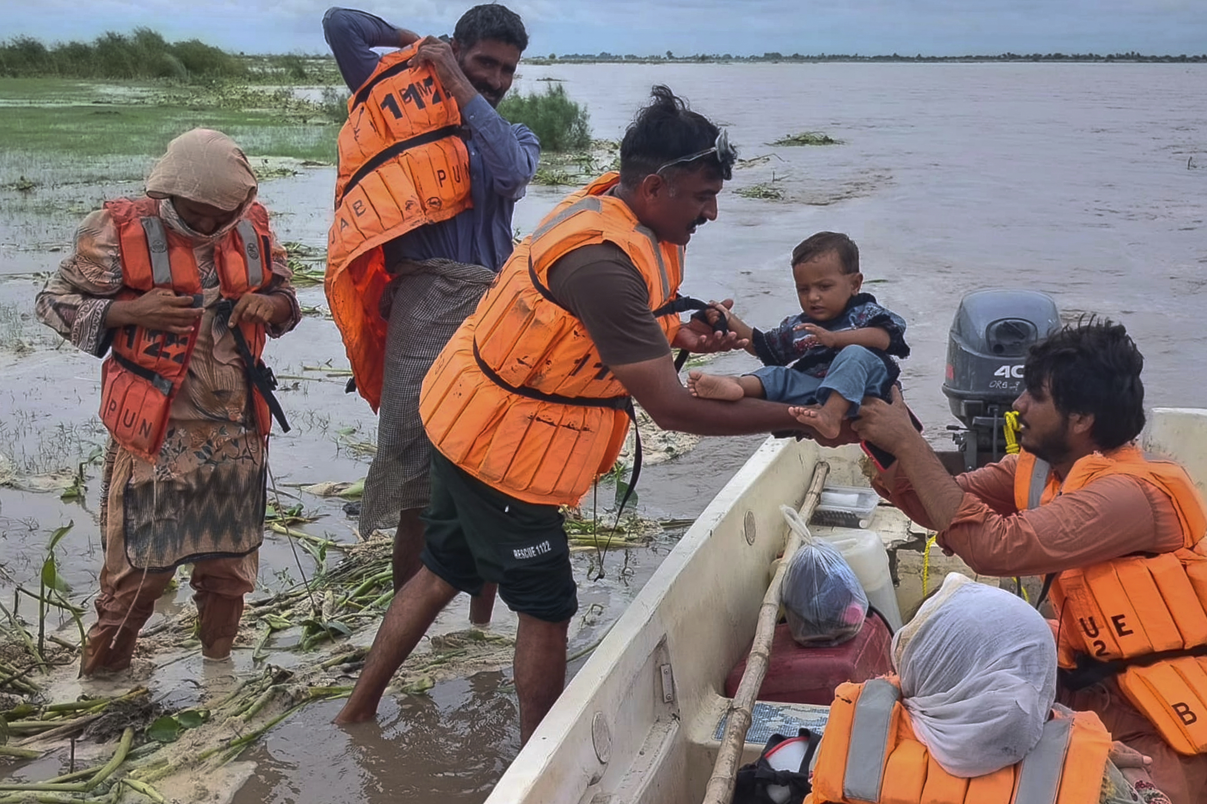 Rescue workers evacuate villagers from a low-lying area.