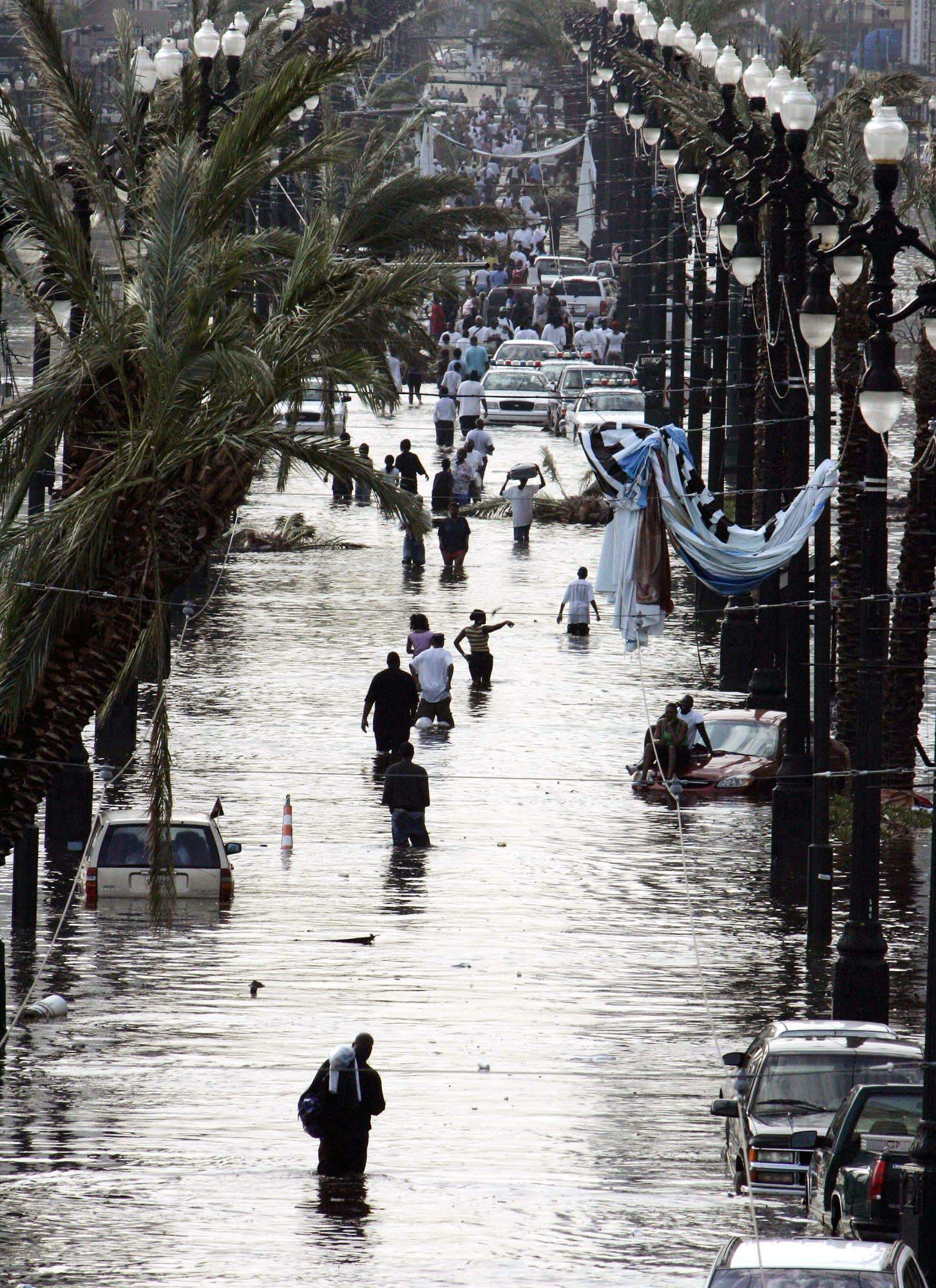 Residents walk through floodwaters on Canal Street in New Orleans on Tuesday, Aug. 30, 2005, after Hurricane Katrina devastated the Louisiana and Mississippi coasts when it came ashore on Monday. (AP Photo/Bill Haber)