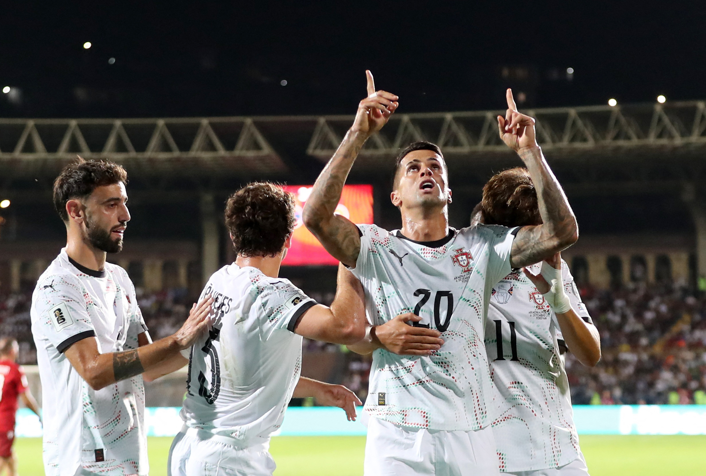 Portugal’s Joao Cancelo points up and looks to the skies as he celebrates scoring his side’s third goal