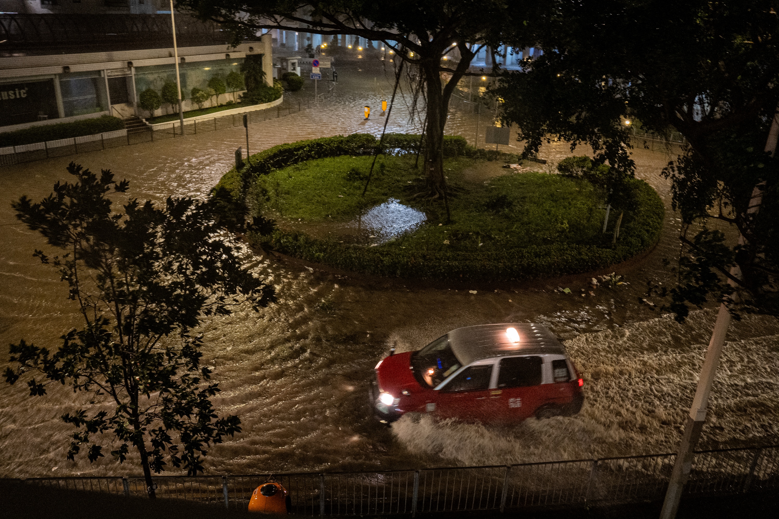 A taxi drives through a flooded area in Heng Fa Chuen caused by Super Typhoon Ragasa in Hong Kong on September 24, 2025. Hong Kong's weather service issued the highest level of typhoon warning in the early hours, as Super Typhoon Ragasa brought powerful winds and lashing rain to the southern Chinese coast. (Photo by Leung Man Hei / AFP)