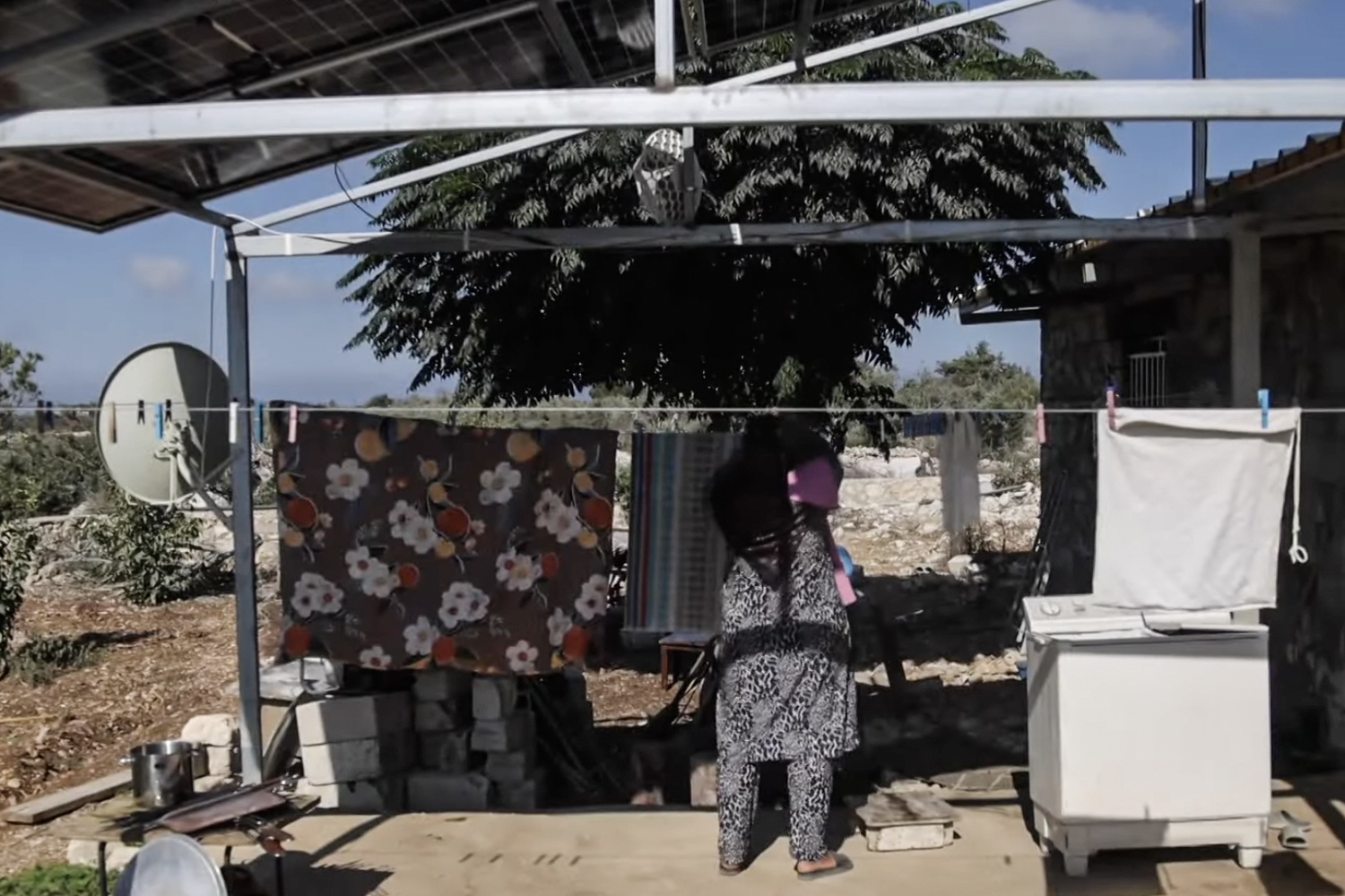 A woman is pictured at her home in a village.