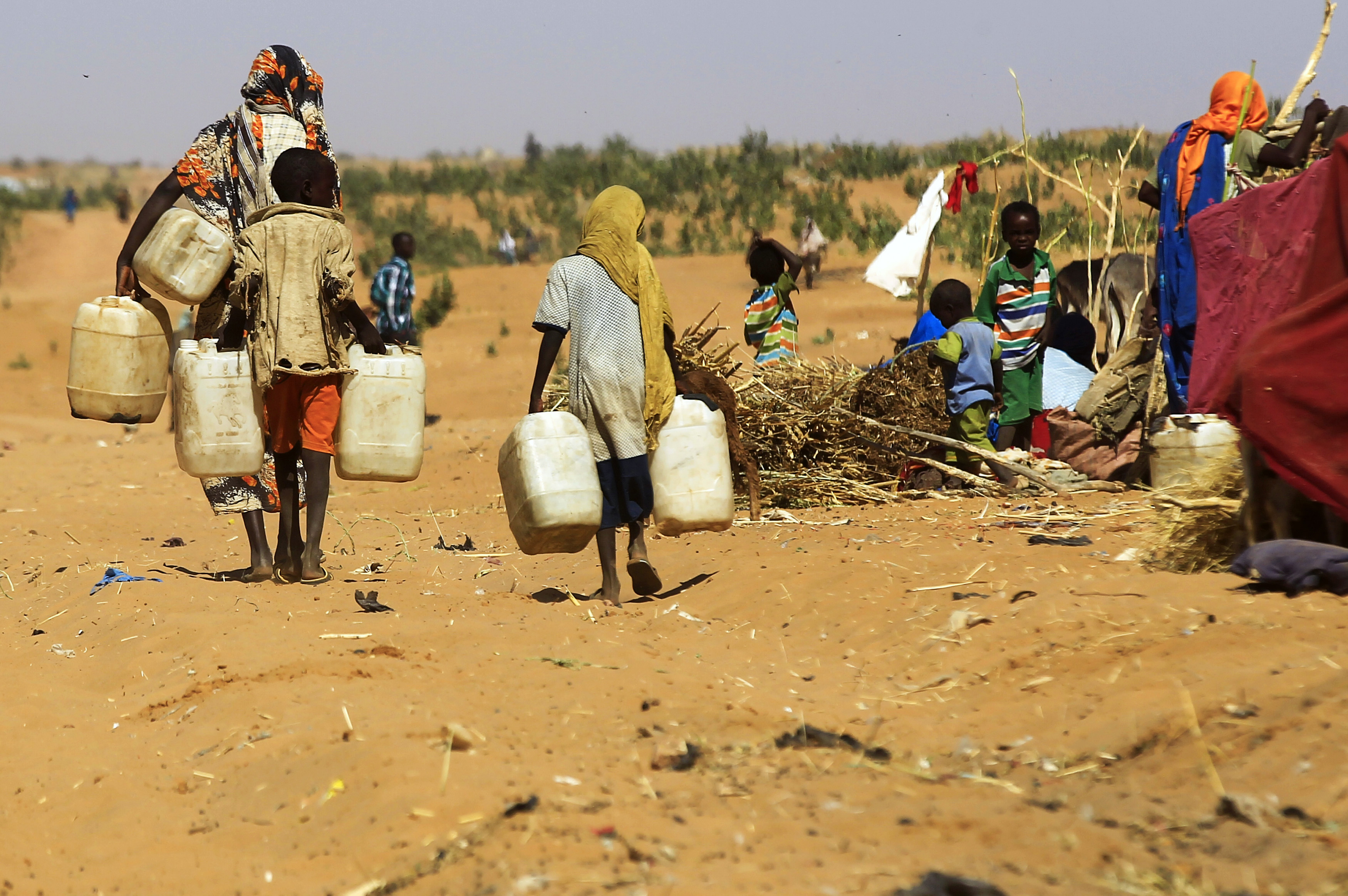 People walk to fill water containers.