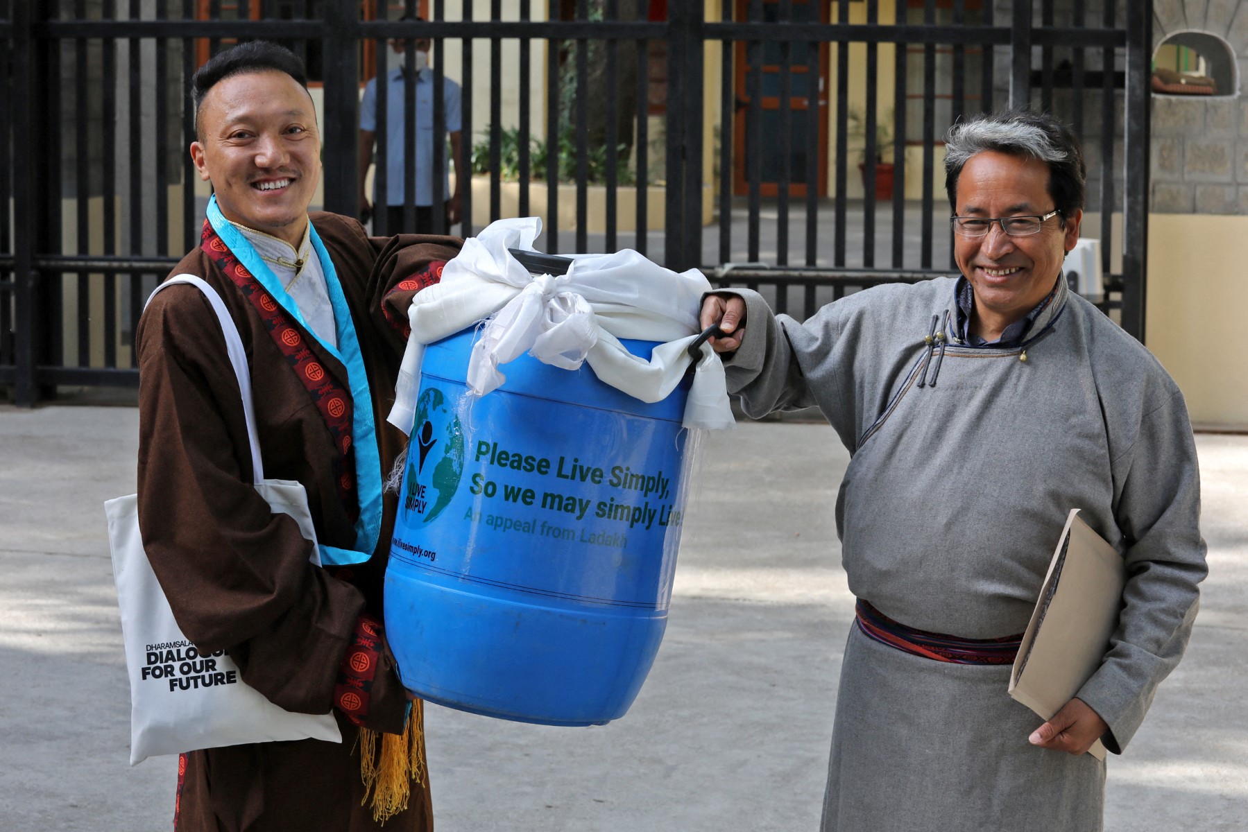 Sonam Wangchuk (R) carries a container with a block of ice from the Khardung La glacier to be presented to the Tibetan spiritual leader, the Dalai Lama, on the occasion of Earth Day at Tsuglakhang in McLeod Ganj, Himachal Pradesh, India, on April 22, 2022 [Photo by AFP]