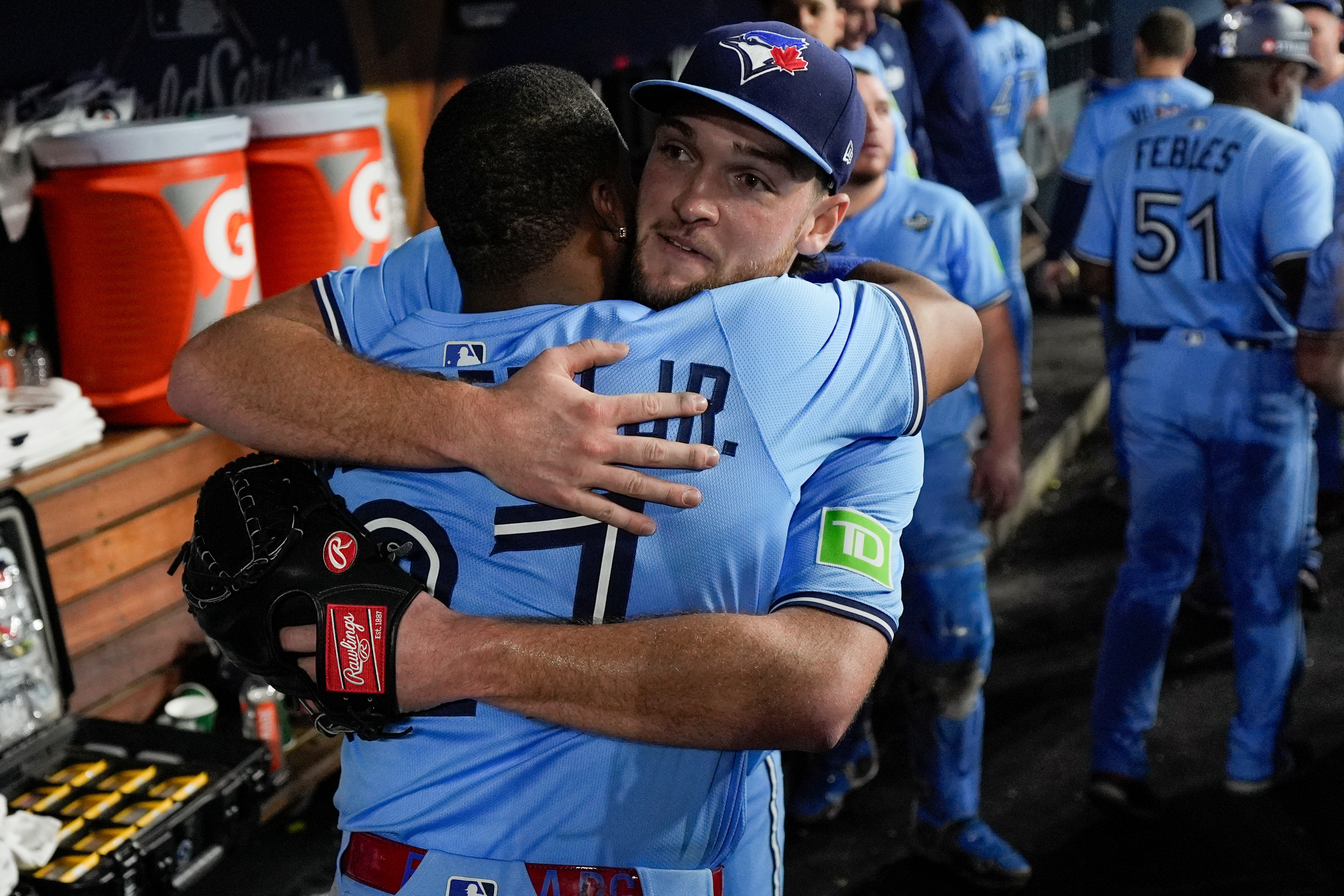 Yesavage hugs Toronto teammate Vladimir Guerrero Jr #27 in the dugout during the seventh inning in Game 5