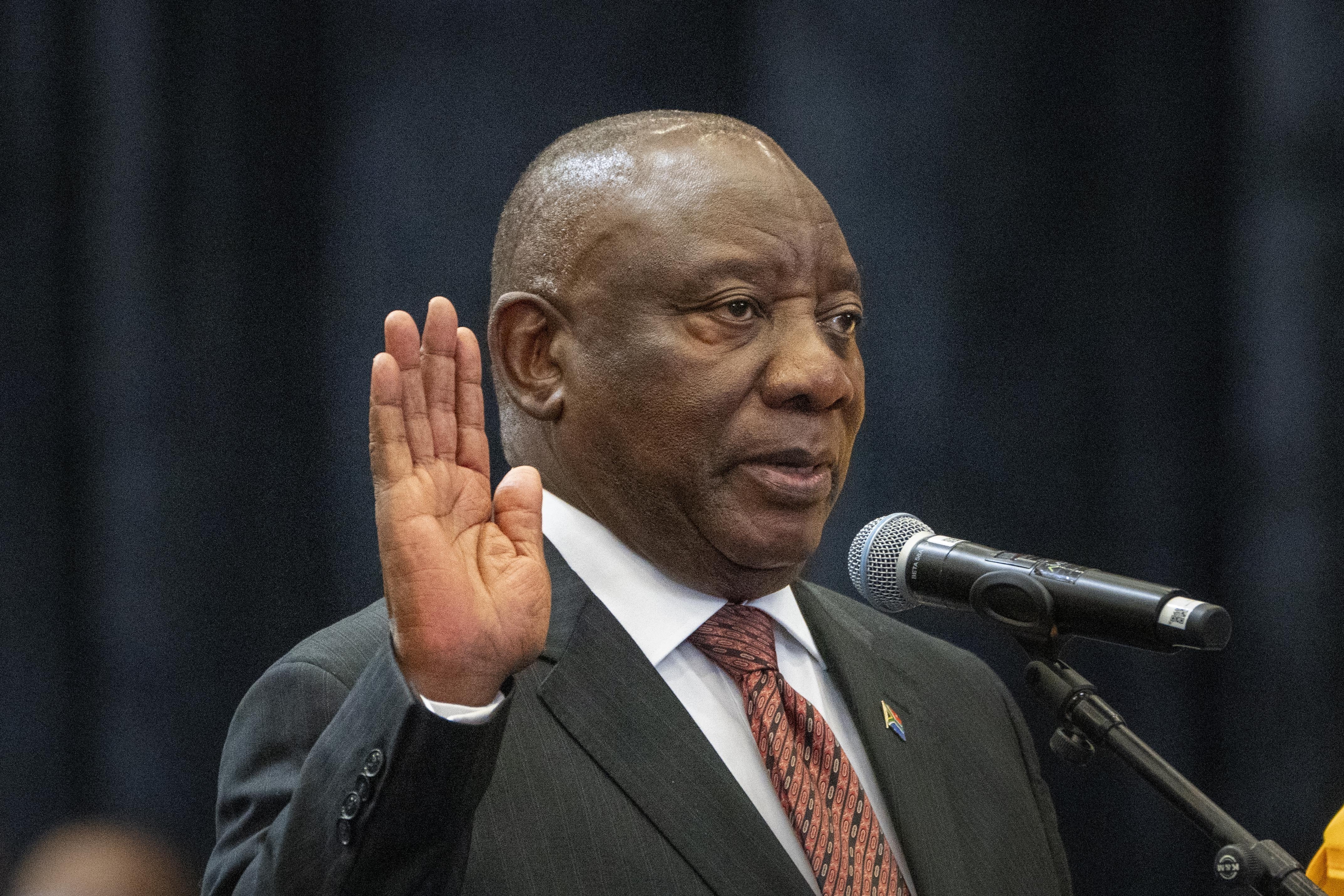 FILE - South African President Cyril Ramaphosa raises his hand as he is sworn is as a member of Parliament ahead of an expected vote by lawmakers to decide if he is reelected as leader of the country in Cape Town, South Africa, June 14, 2024. (AP Photo/Jerome Delay, file)