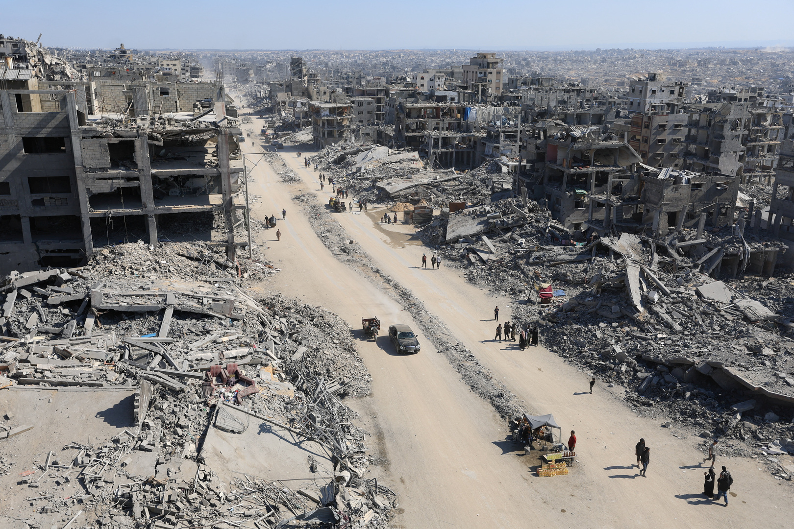 Palestinians walk past the rubble of destroyed buildings, amid a ceasefire between Israel and Hamas, in Gaza City on Oct. 16, 2025. [Dawoud Abu Alkas/Reuters]