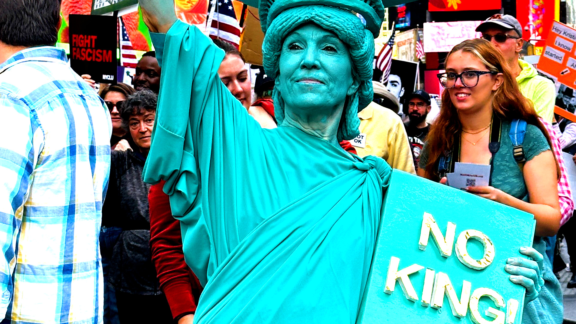 Jennifer Stewart, one of thousands of protesters who descended on New York City&rsquo;s Times Square for the &ldquo;No Kings&rdquo; demonstration opposing US President Donald Trump, flaunts a Statue of Liberty costume at the planned demonstration that drew millions of people from around the country on Oct. 18, 2025 [Dorian Geiger/Al Jazeera]