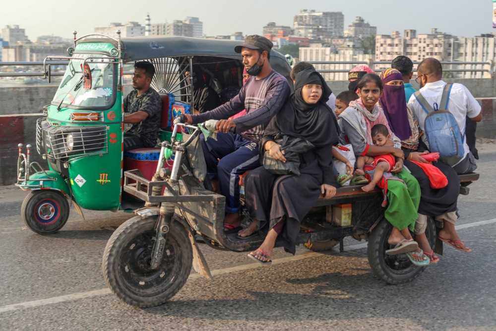 People cross the second Buriganga bridge on rickshaws and motorcycles in Dhaka, Bangladesh, on October 23, 2025