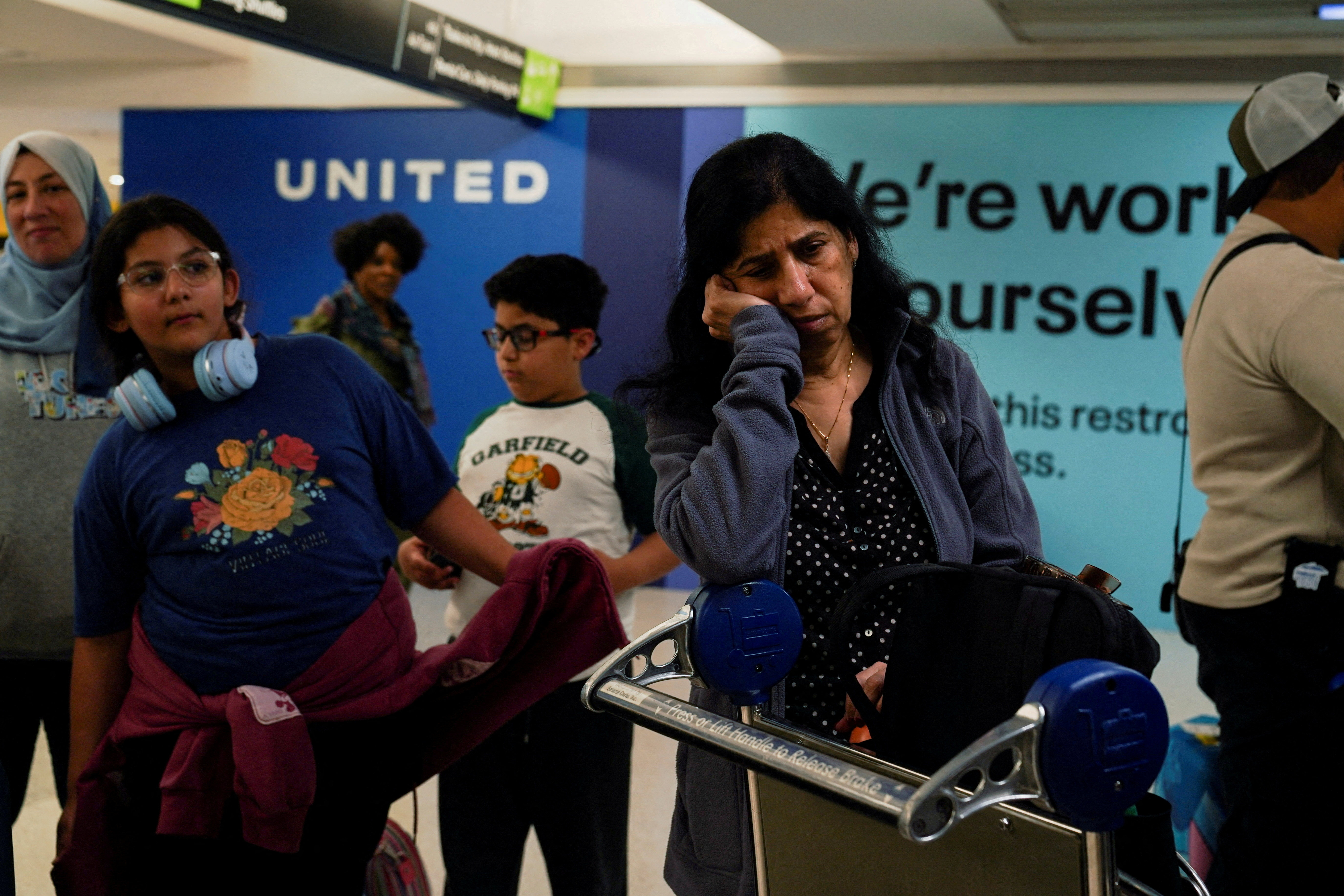 A traveler awaits their delayed luggage after United Airlines grounded flights due to a tech outage at Newark Liberty International Airport in Newark, New Jersey, U.S