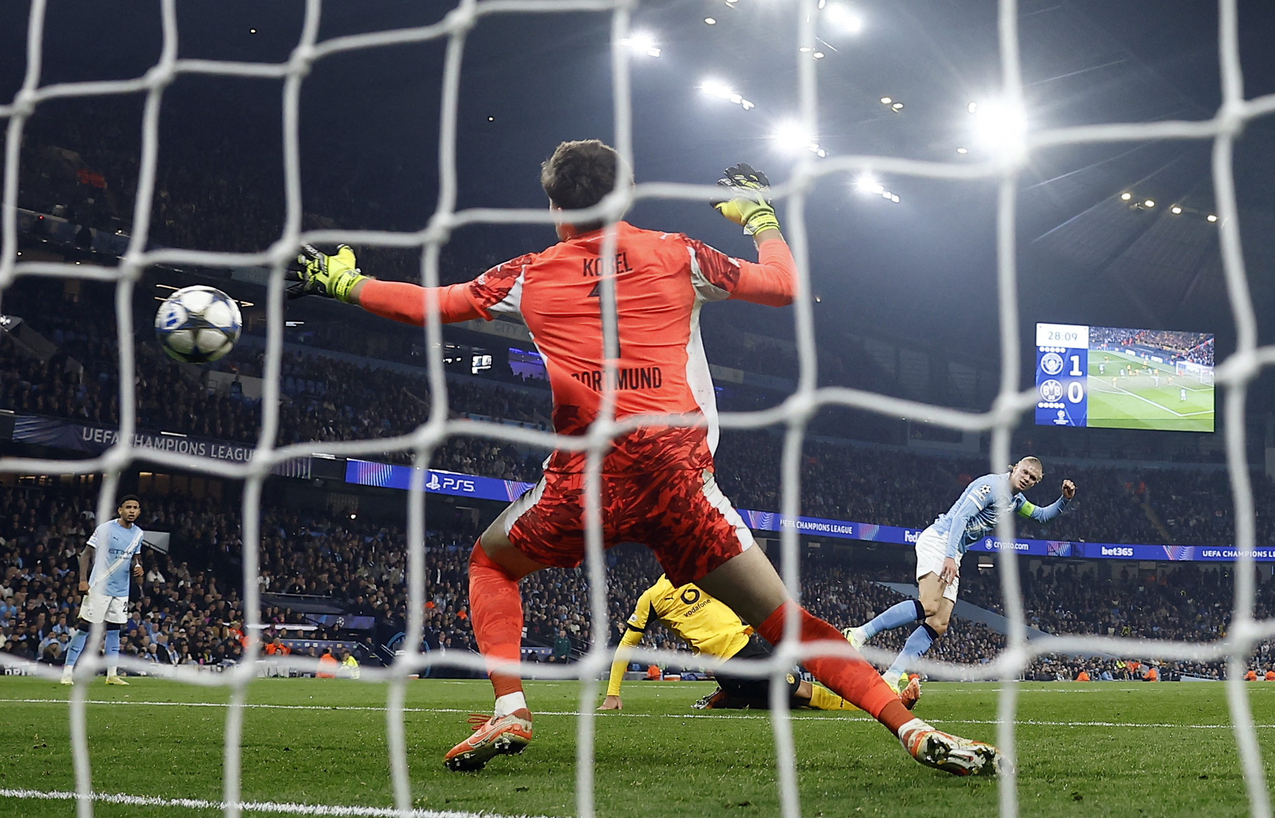 Manchester City’s Erling Haaland, right, scores their second goal as Borussia Dortmund’s Gregor Kobel attempts to make a save