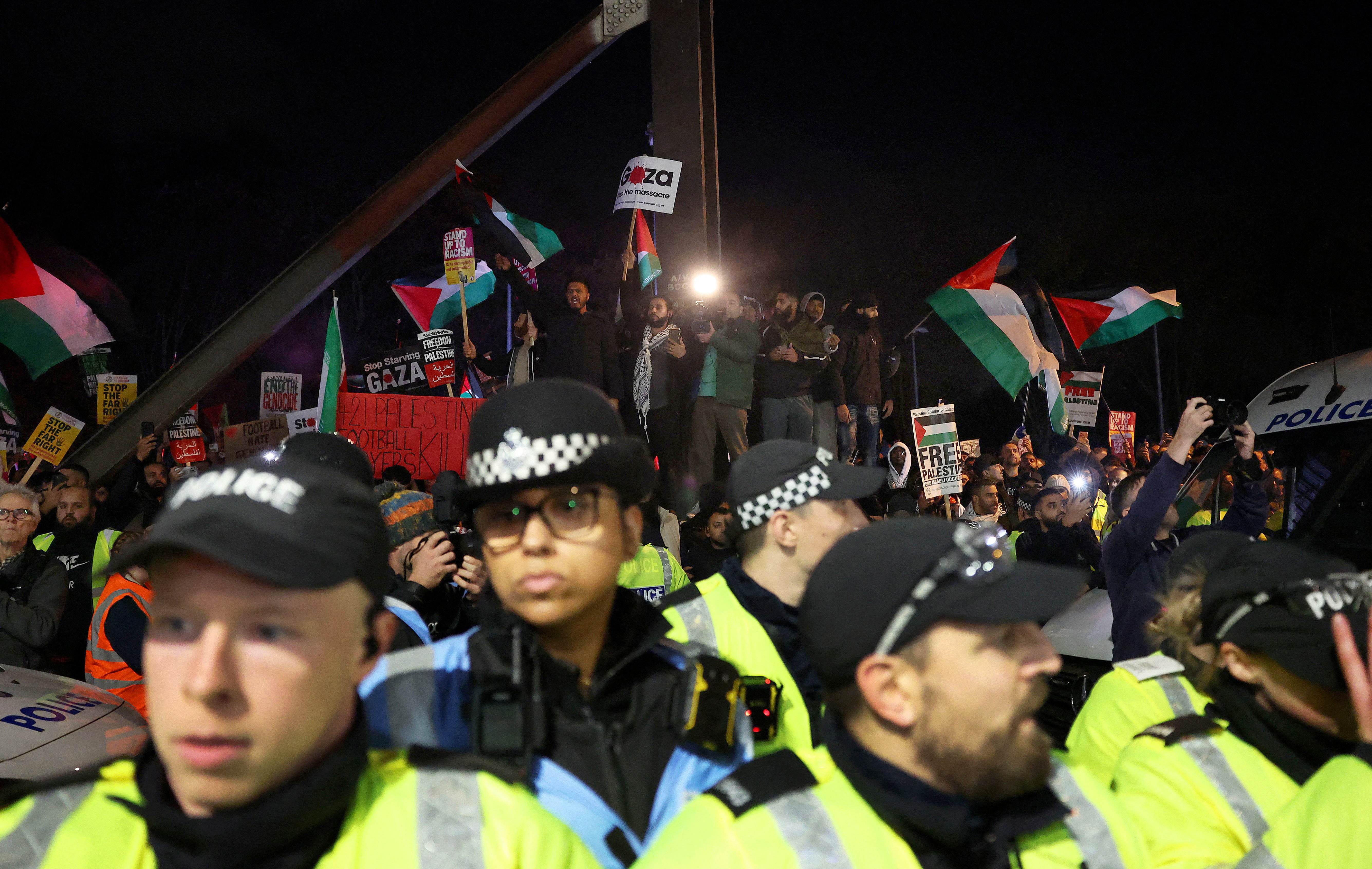 Police officers and protesters outside the stadium before the match.