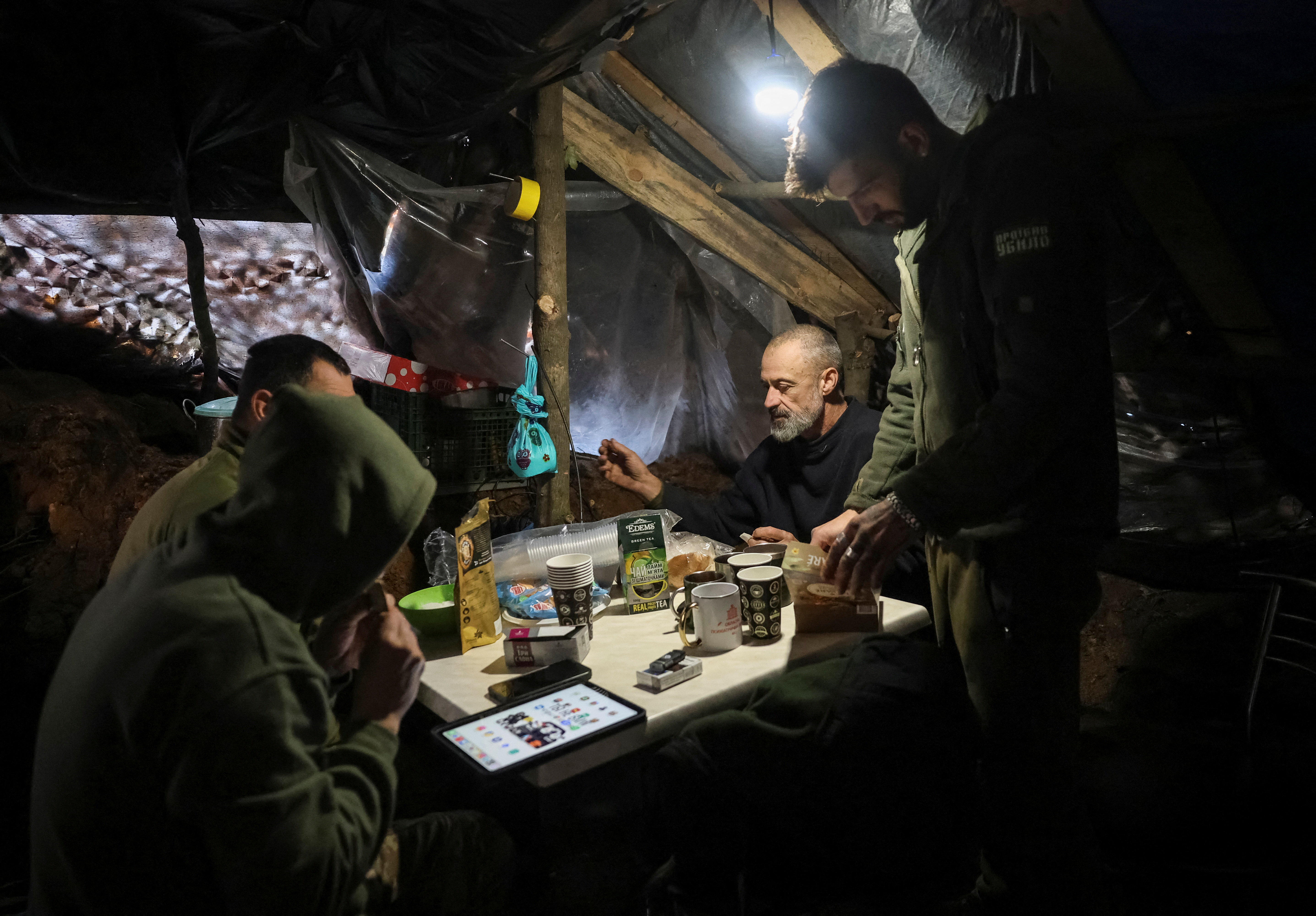 Ukrainian servicemen rest in a dugout.