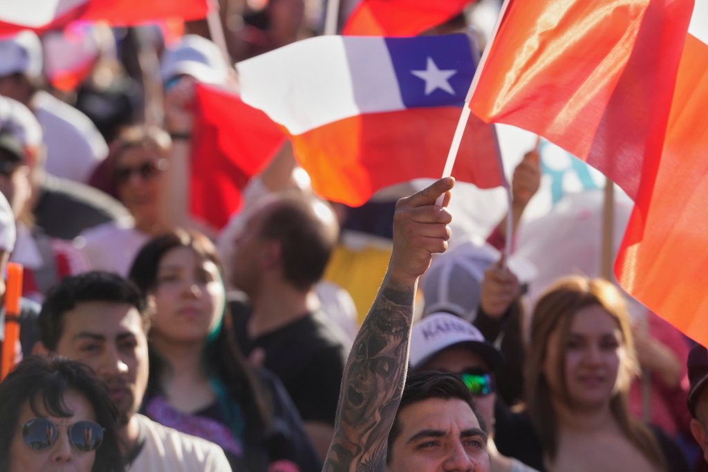 People hold Chilean flags at a political rally
