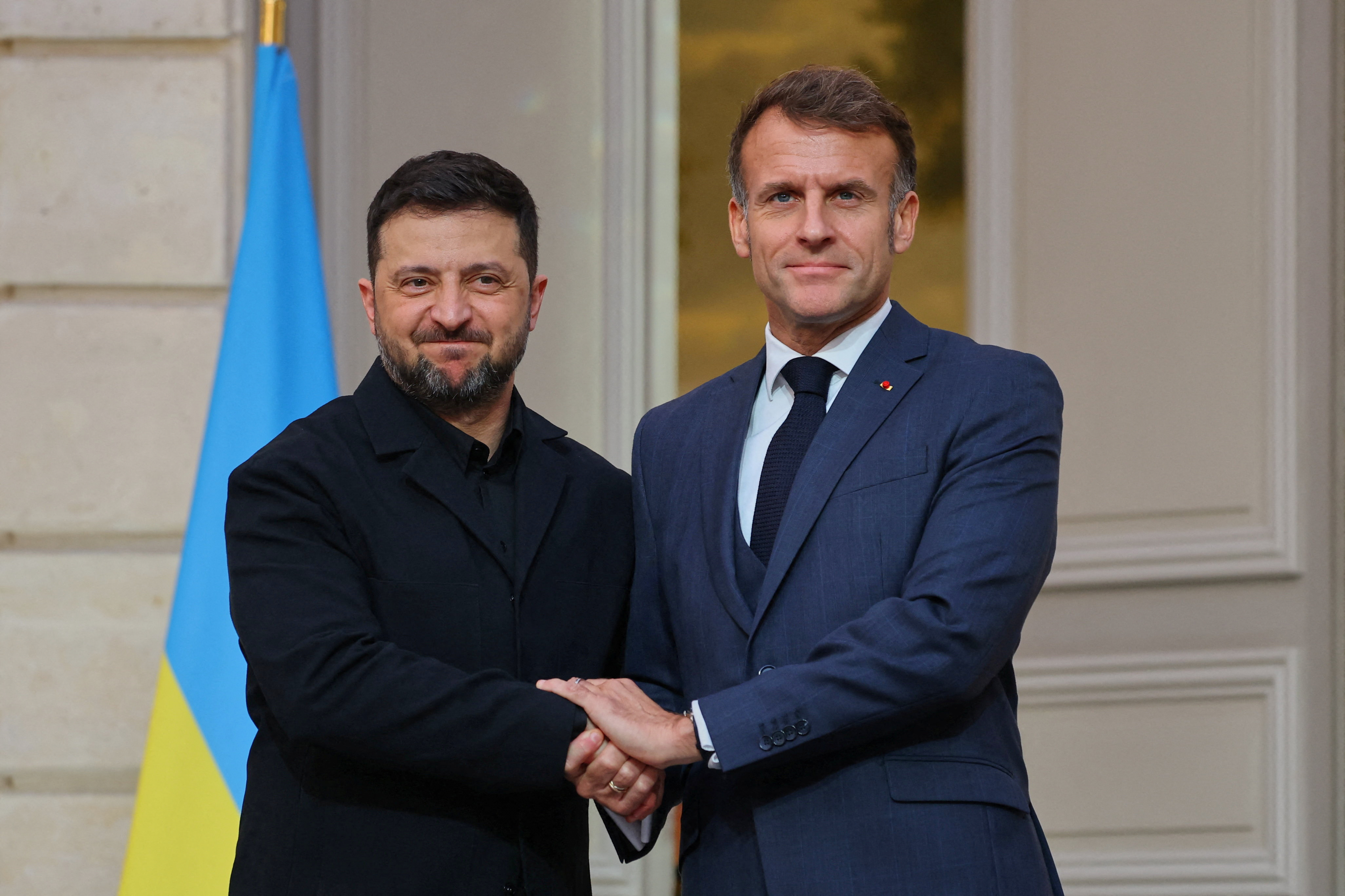 Ukrainian President Volodymyr Zelenskyy, left, and French President Emmanuel Macron shake hands after a joint media conference at the Elysee Palace in Paris on November 17, 2025.